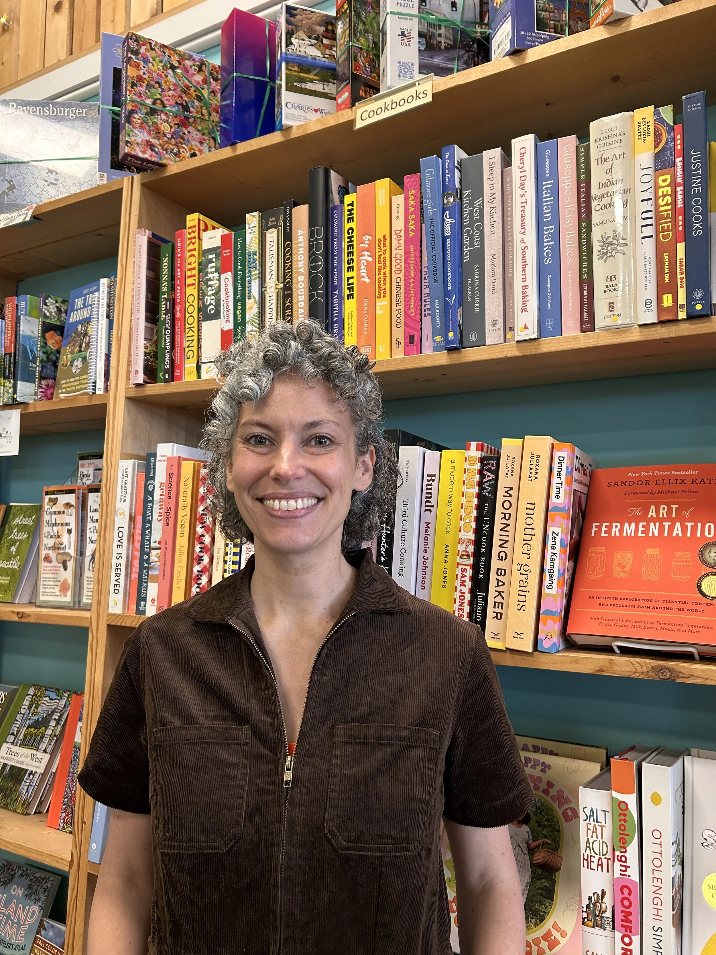 Peggy stands smiling in the bookstore.