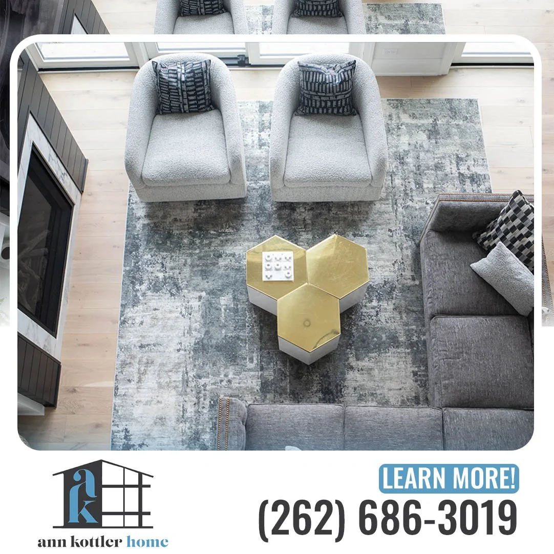 Overhead view of a contemporary living room with gray seating, abstract rug, and gold hexagonal coffee tables