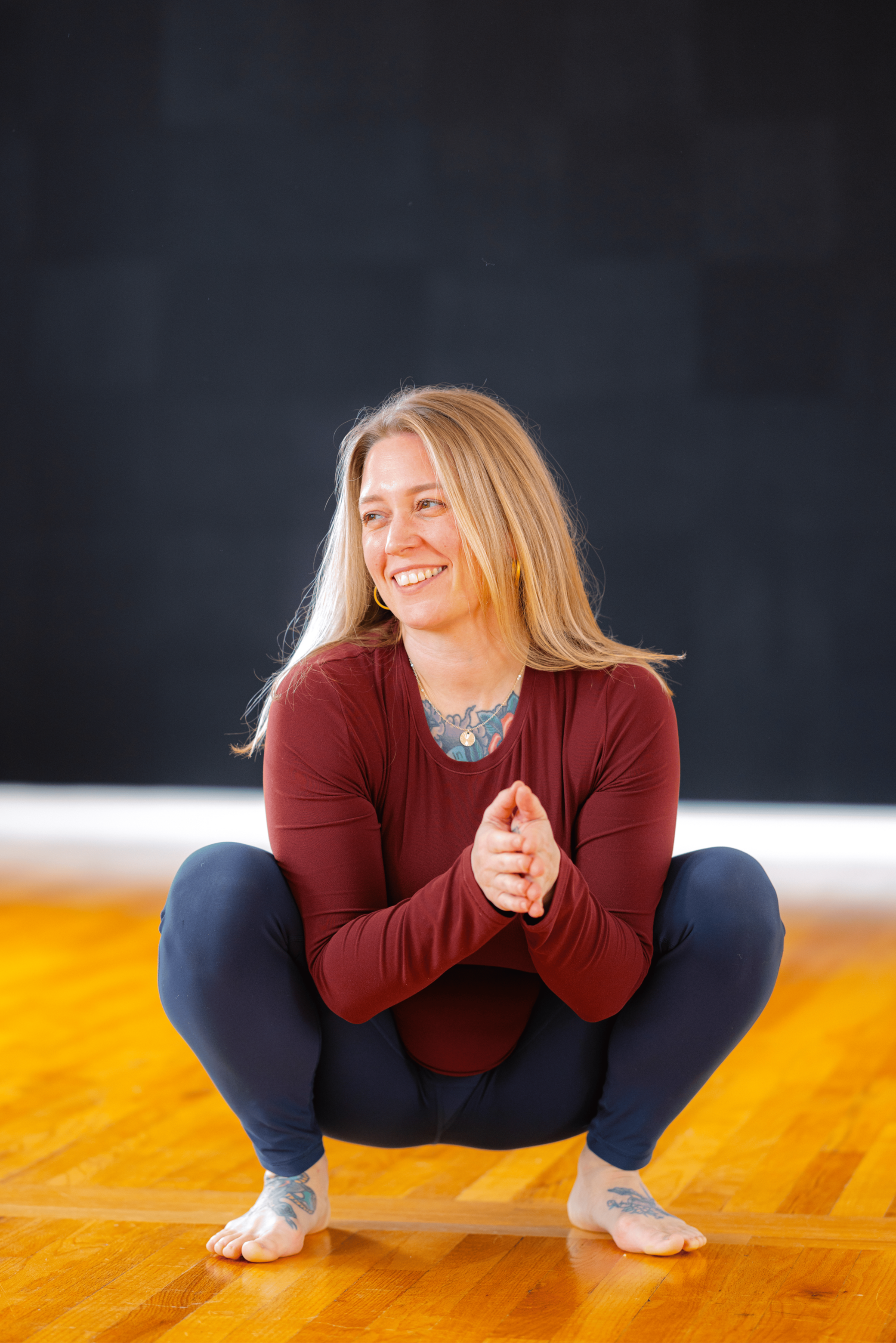 Lauren Reek private yoga teacher Long Island smiling in squat pose Massapequa studio
