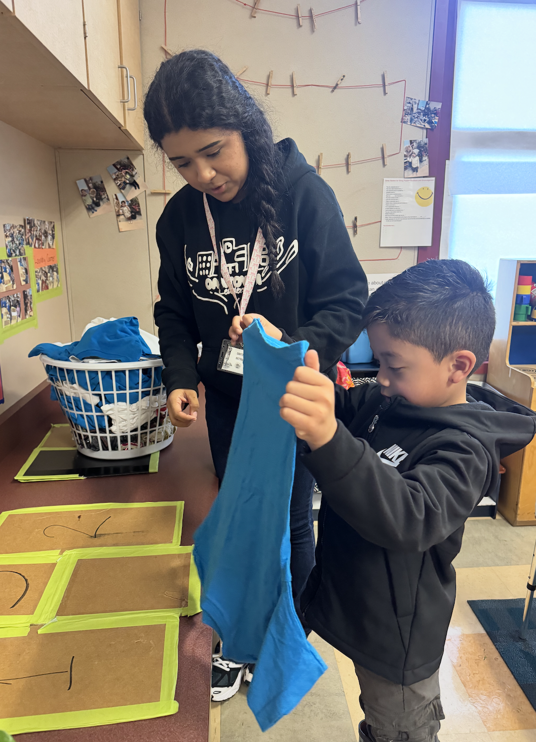 teacher helping child with folding