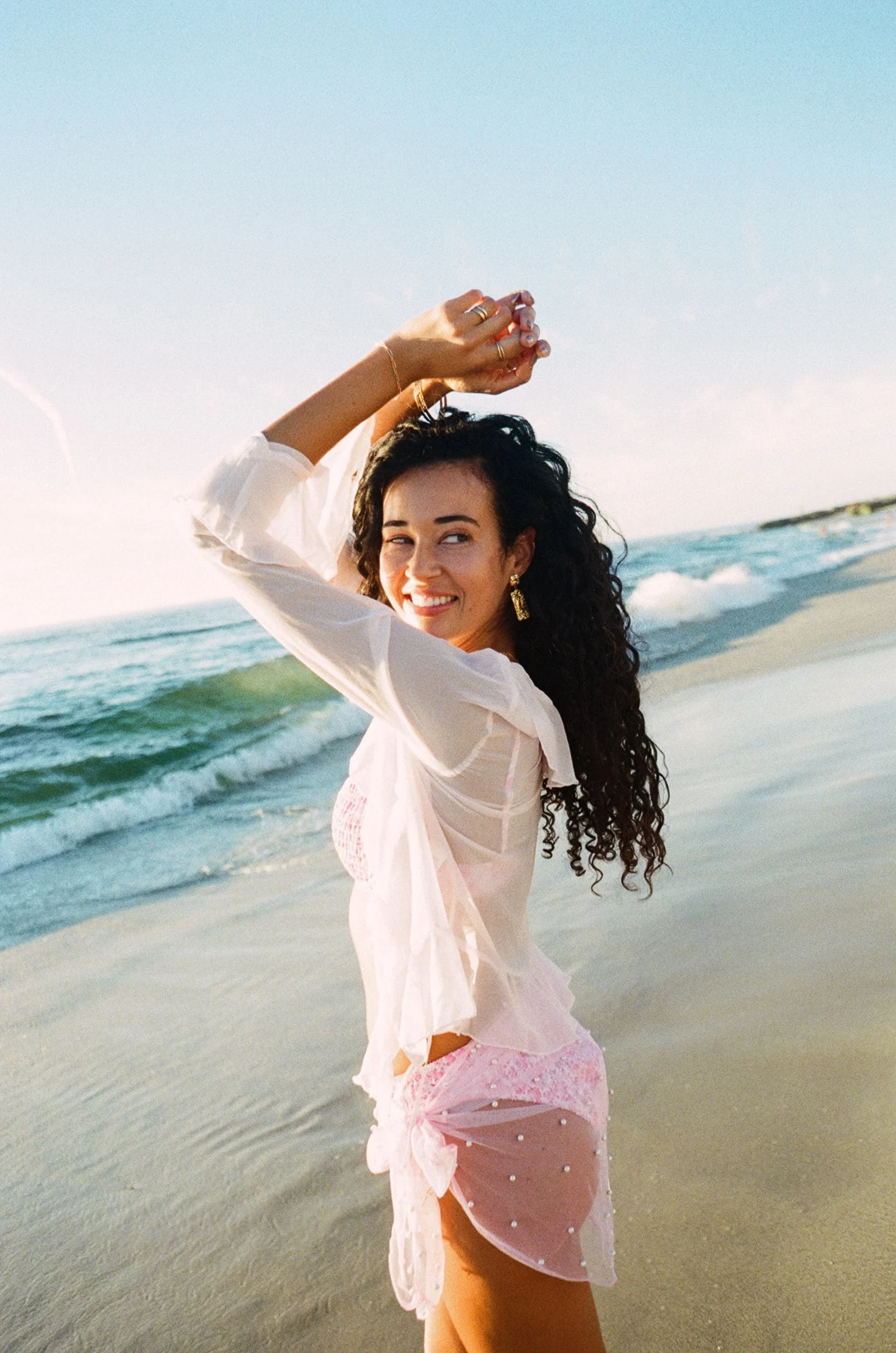 woman walking towards the ocean after her spray tan appointment