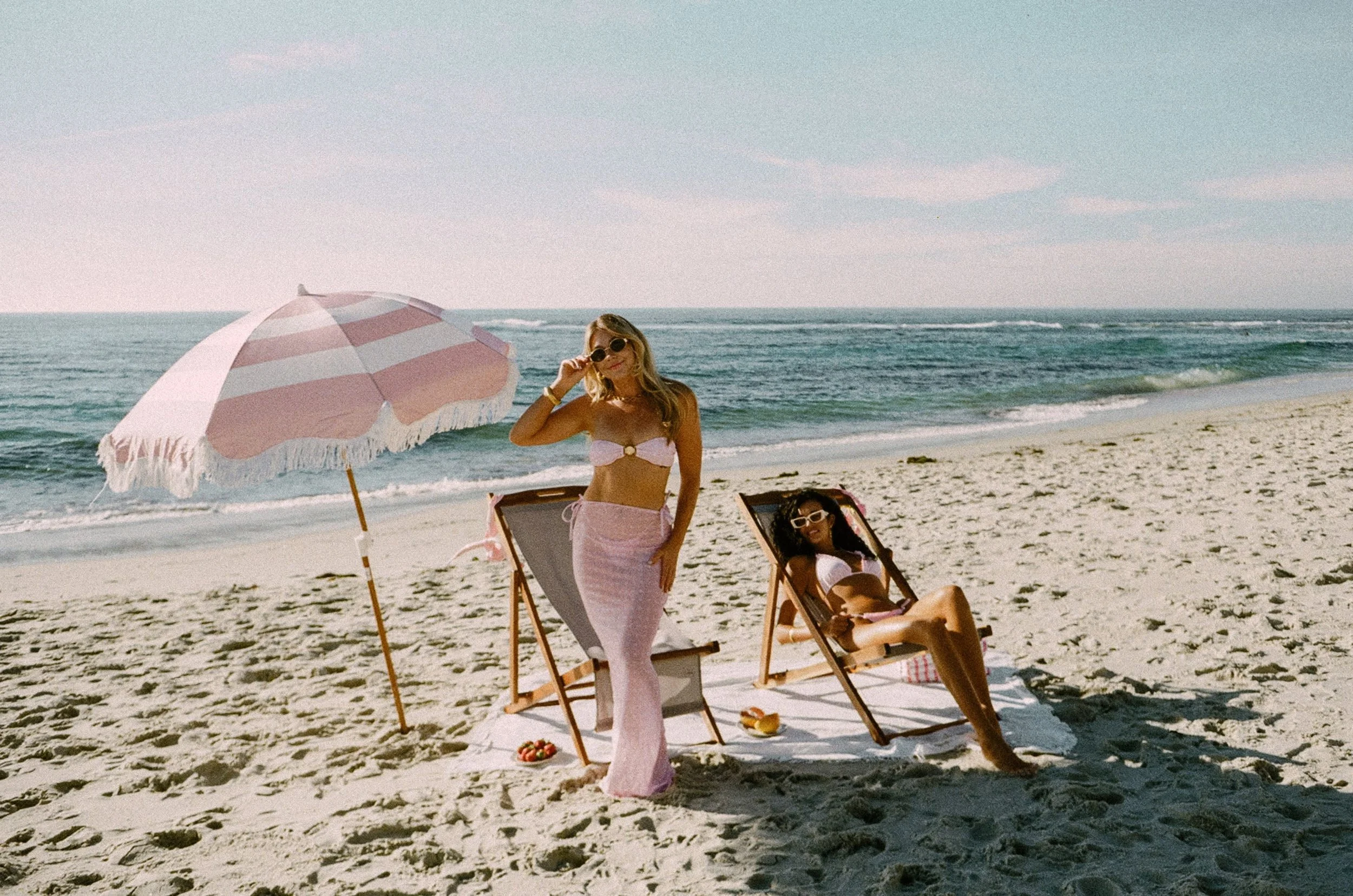 women relaxing at beach with their flawless airbrushed pray tans