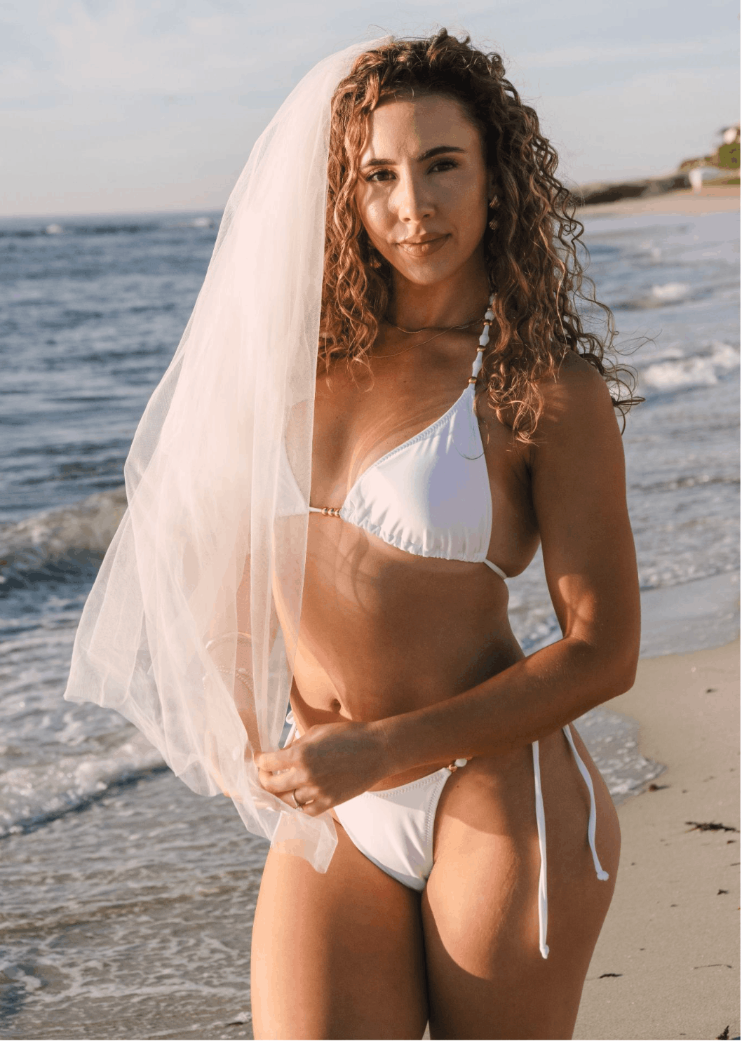 bride at the beach wearing white bikini