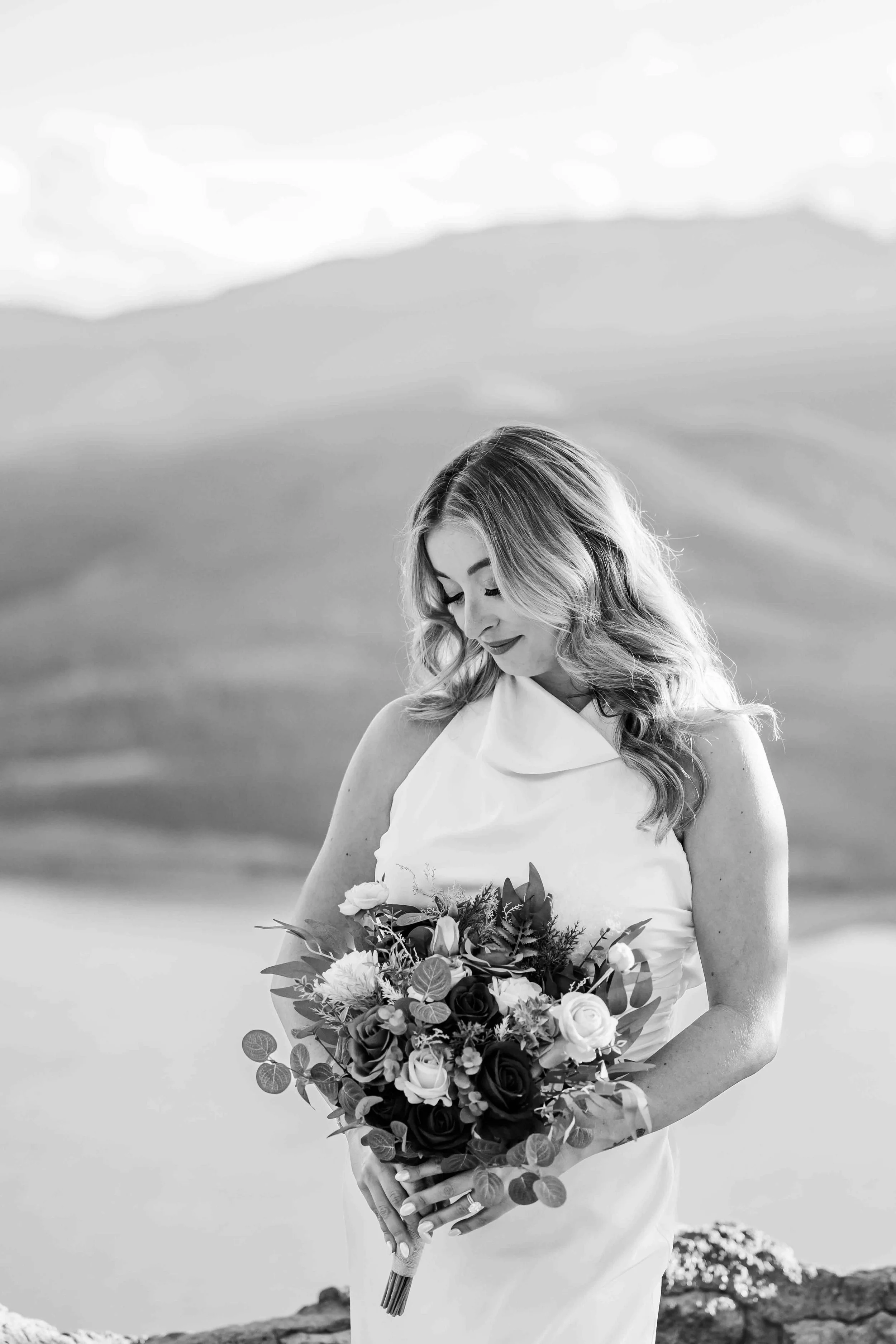 30_bride-in-halter-dress-stands-holding-bouquet-colorado-wedding.jpg