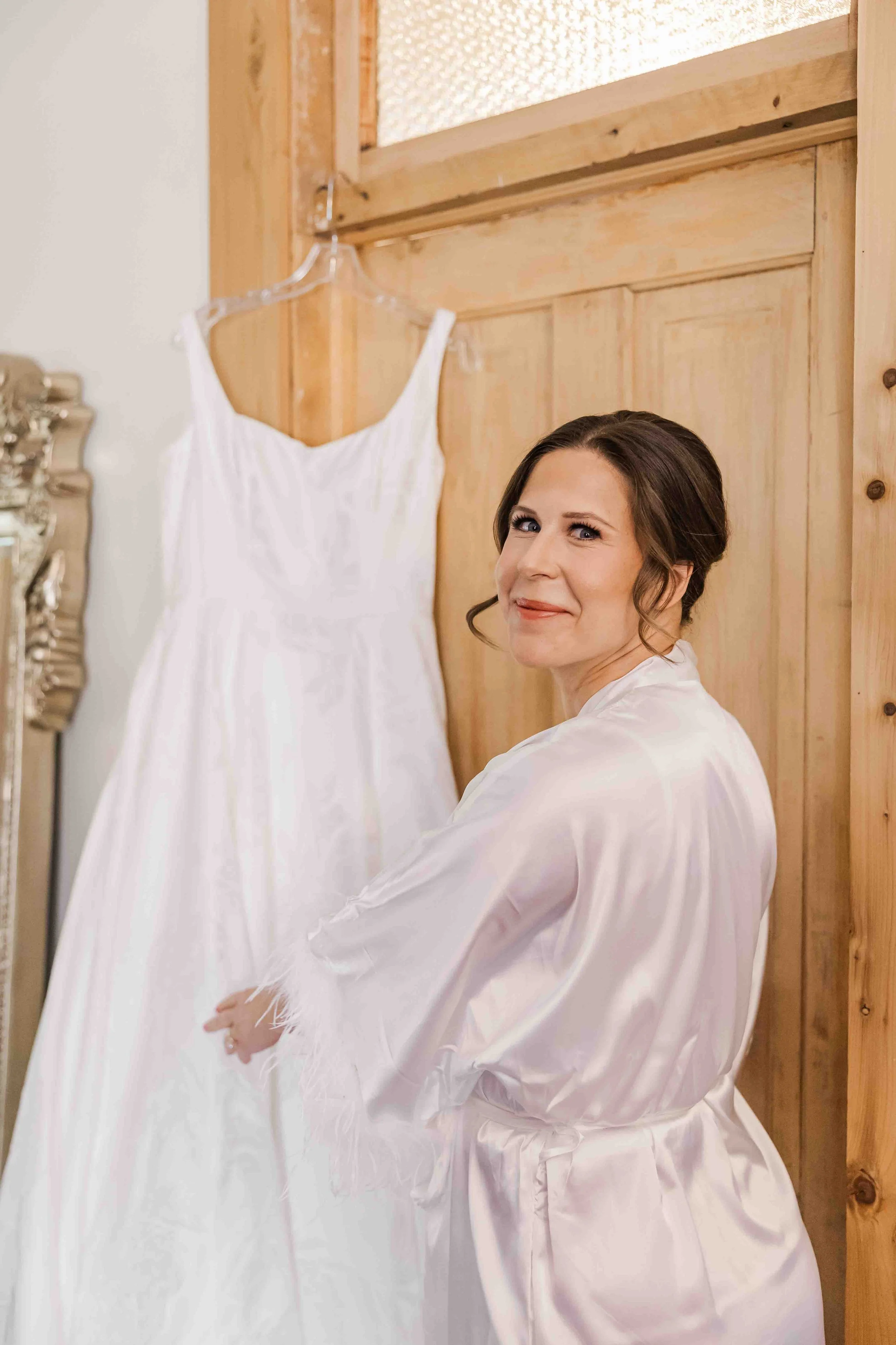 05_bride-stands-with-wedding-dress-on-wedding-morning.jpg