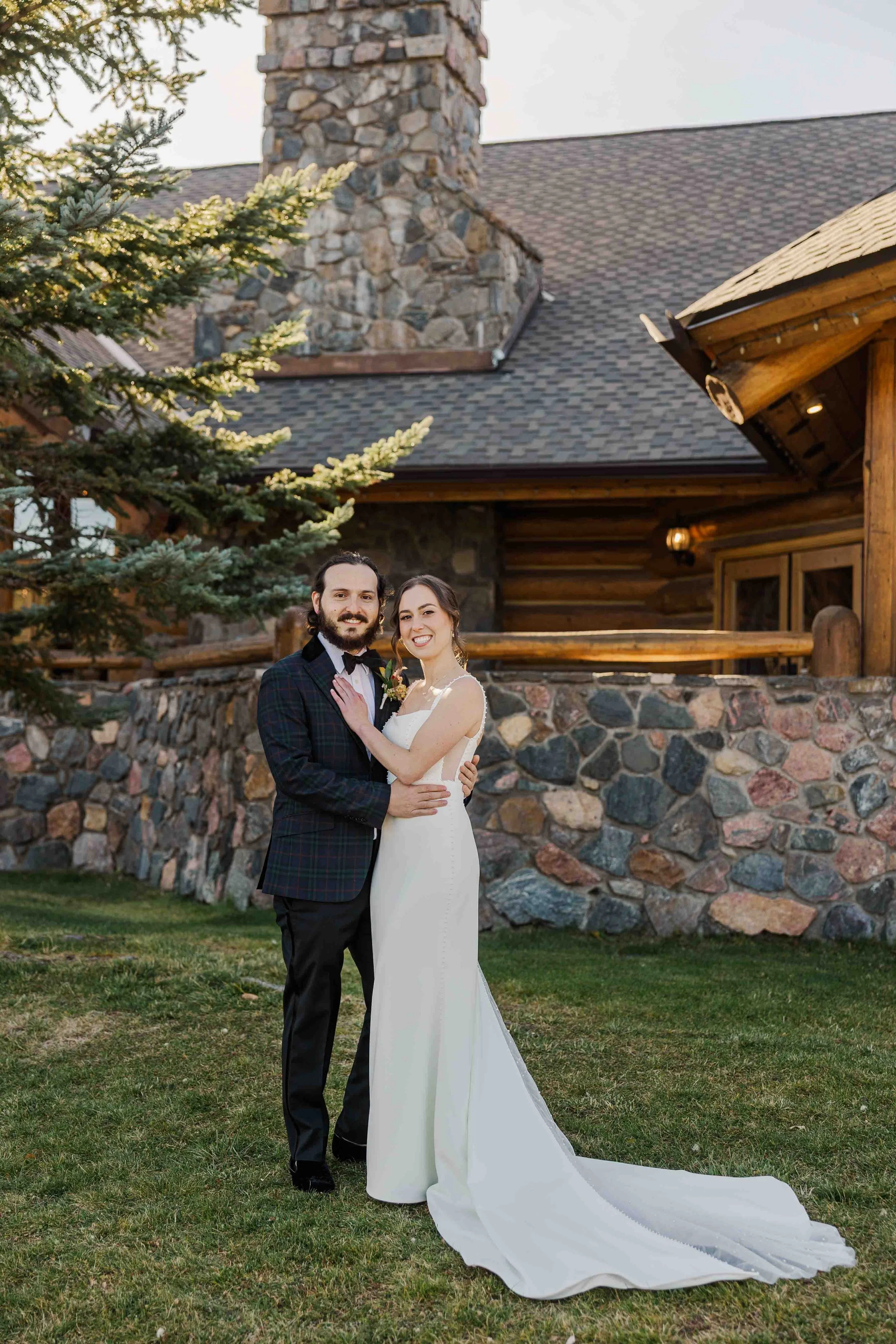07_newly-weds-smile-at-camera-outside-cabin-wedding-venue-colorado.jpg