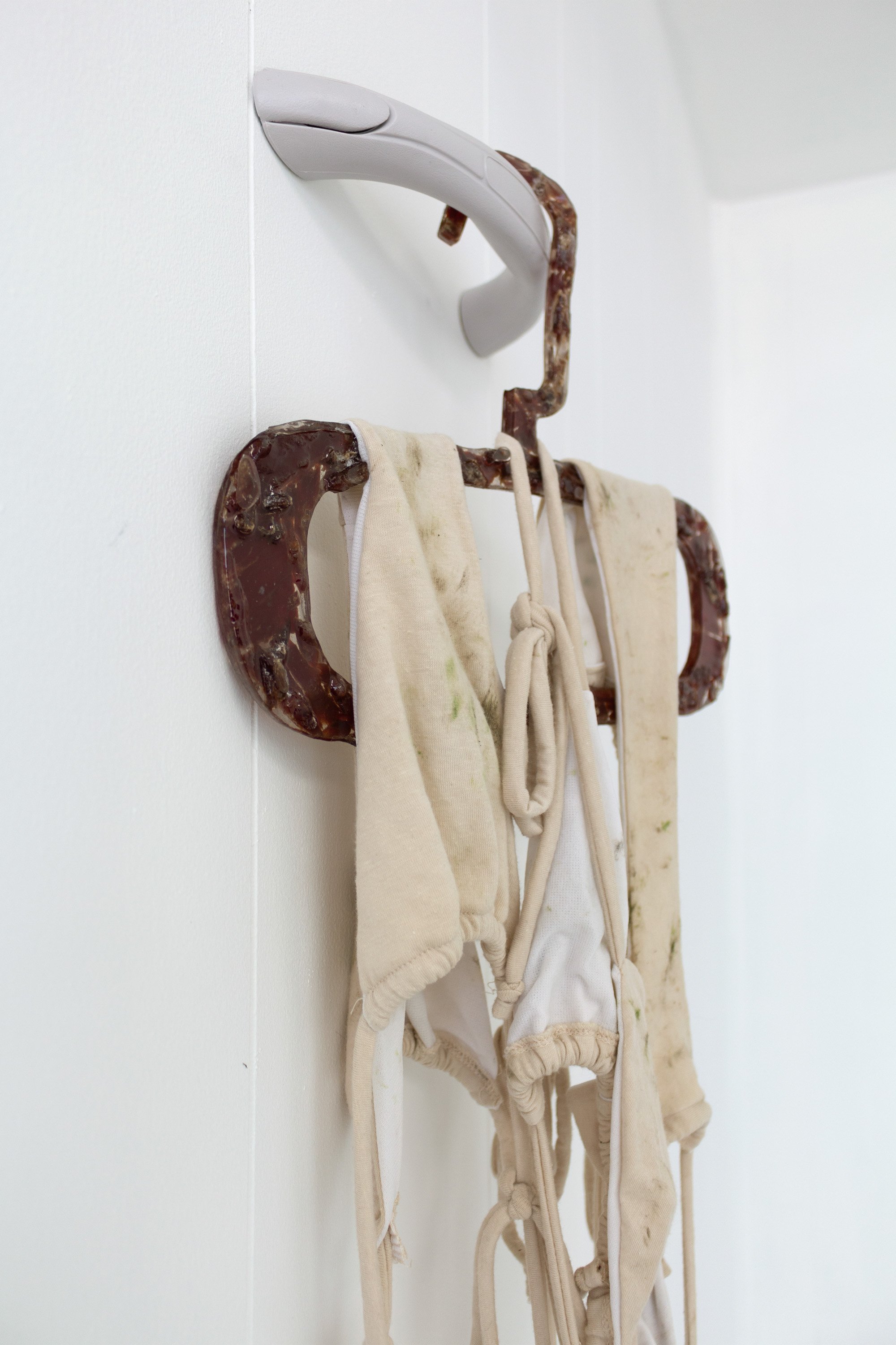  Maeve Coughlin  Untitled (airdry) , 2022 (detail) Vinyl car grab handle, Jack Links jerky, resin, cotton jersey, grass, dirt, and lake water Dimensions variable 