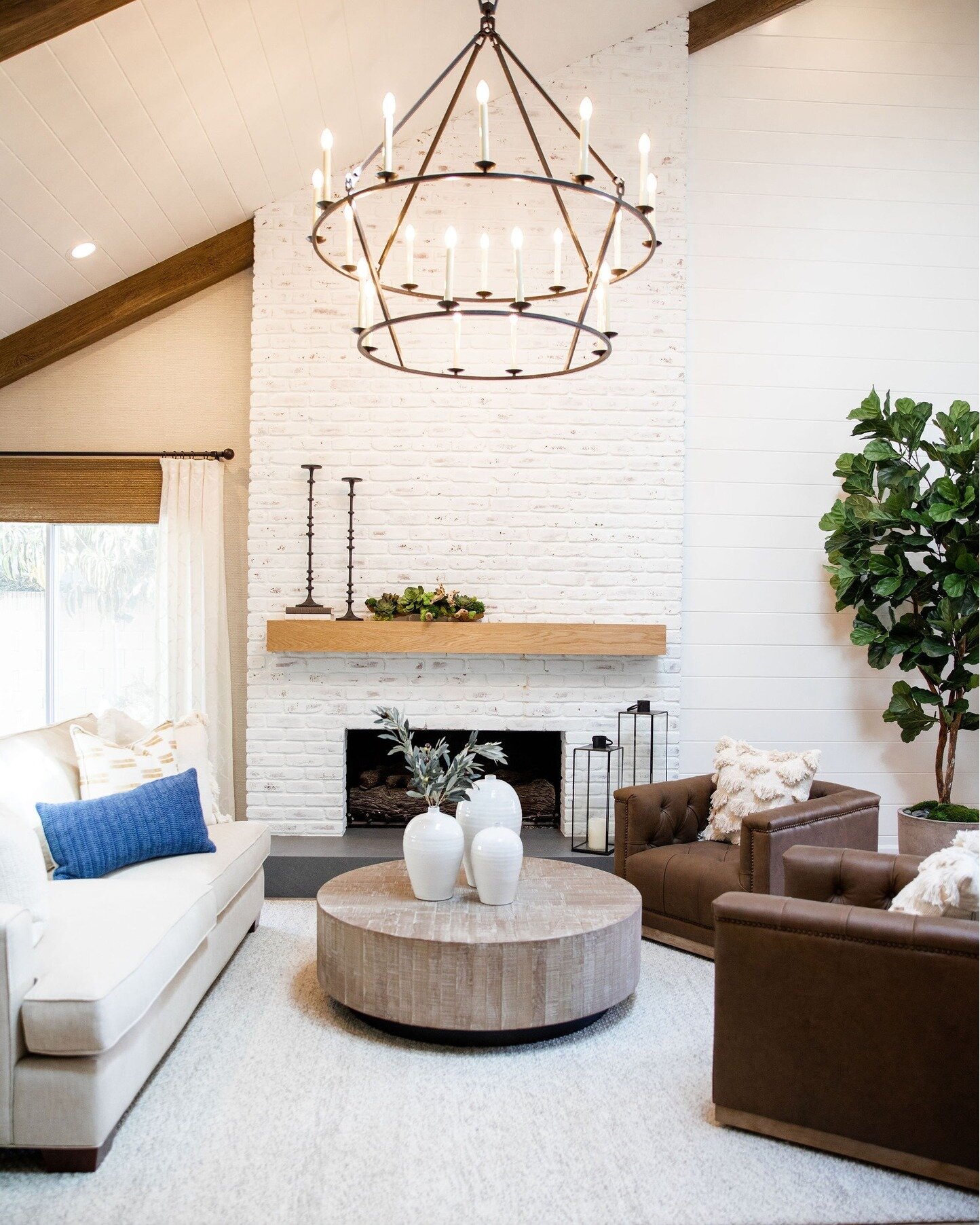 Sunlight spills through the sheer curtains, casting a warm glow on this serene living room designed by Gracious Living. Natural textures and calming greens create a space that invites relaxation and rejuvenation. 

What design element in your home br