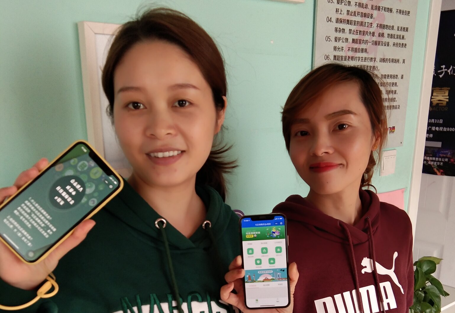 Two young Chinese females holding smartphones