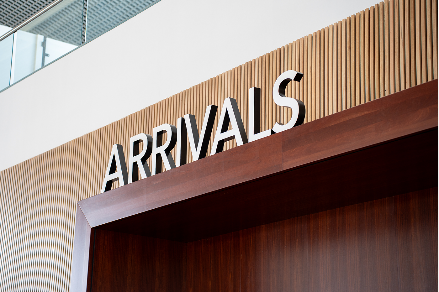 Cairns International T1 Airport. Airport arrivals sign with wood paneling background. Airport Interior Design Brisbane Australia