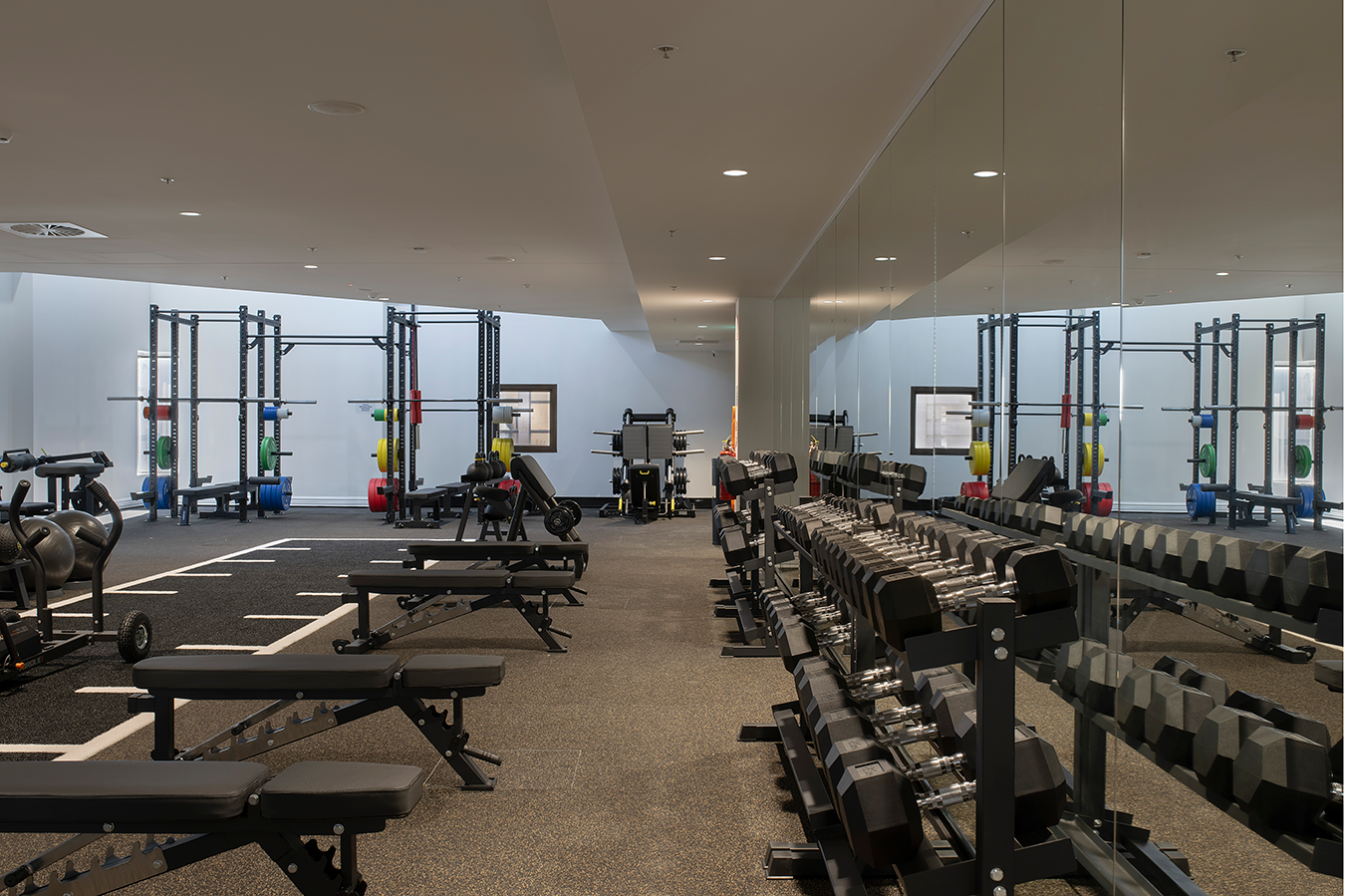 Tattersall's Club. Modern gym interior with weightlifting equipment, dumbbells, benches, and mirrored wall. Hospitality Interior Design Brisbane Australia