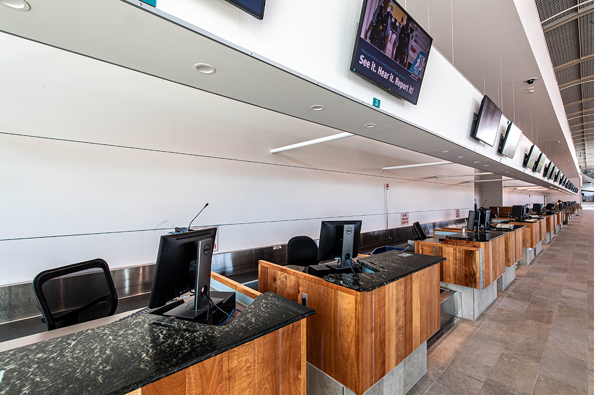 Cairns International T1 Airport. Empty airport check-in counters with computers and monitors, wood and metal design. Airport Interior Design Brisbane Australia