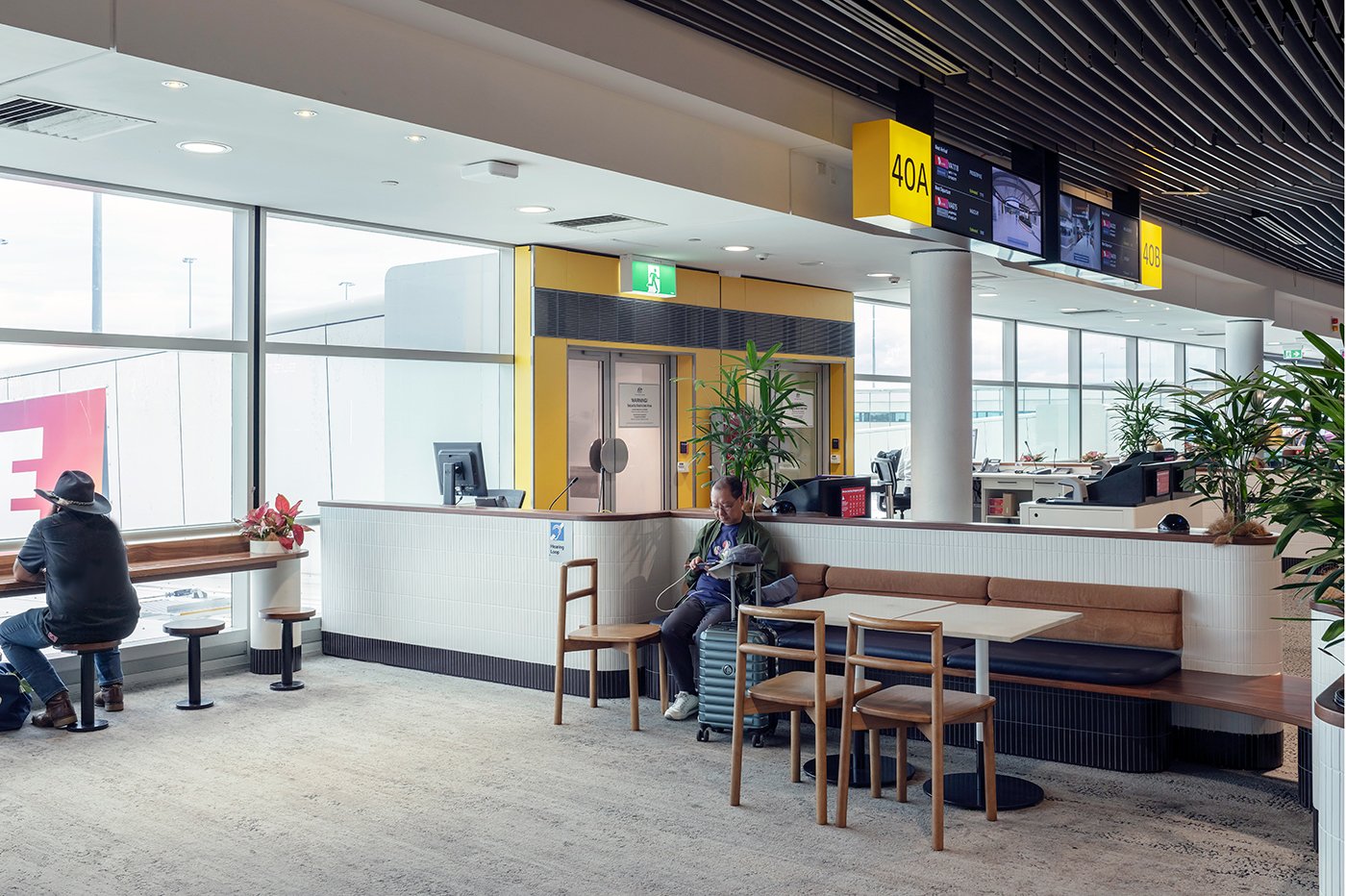 Airport seating area with passengers and gate signs Brisbane Airport Domestic Terminal. Retail Interior Design Australia