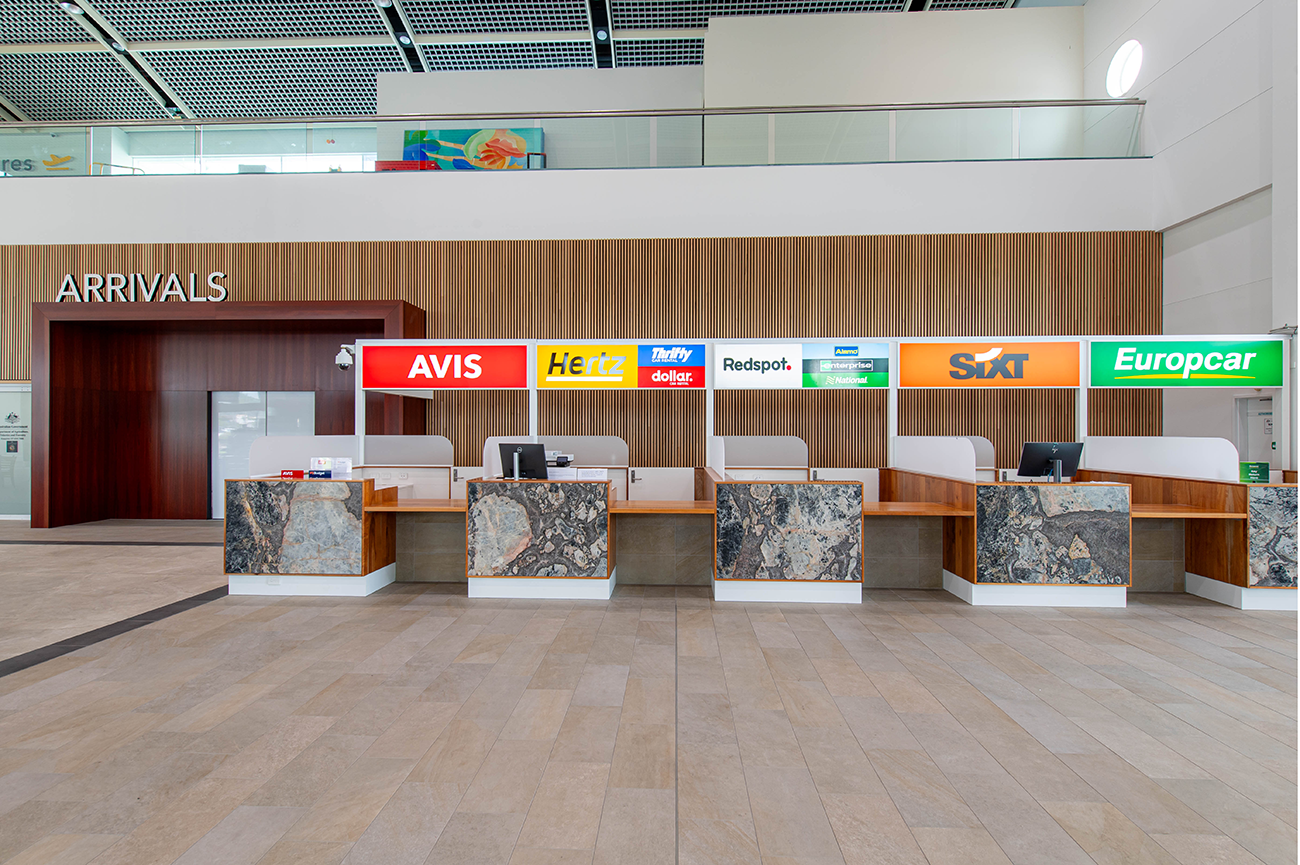 Cairns International T1 Airport. Car rental counters for Avis, Hertz, Thrifty, Redspot, Sixt, and Europcar at an airport arrivals area. Airport Interior Design Brisbane Australia