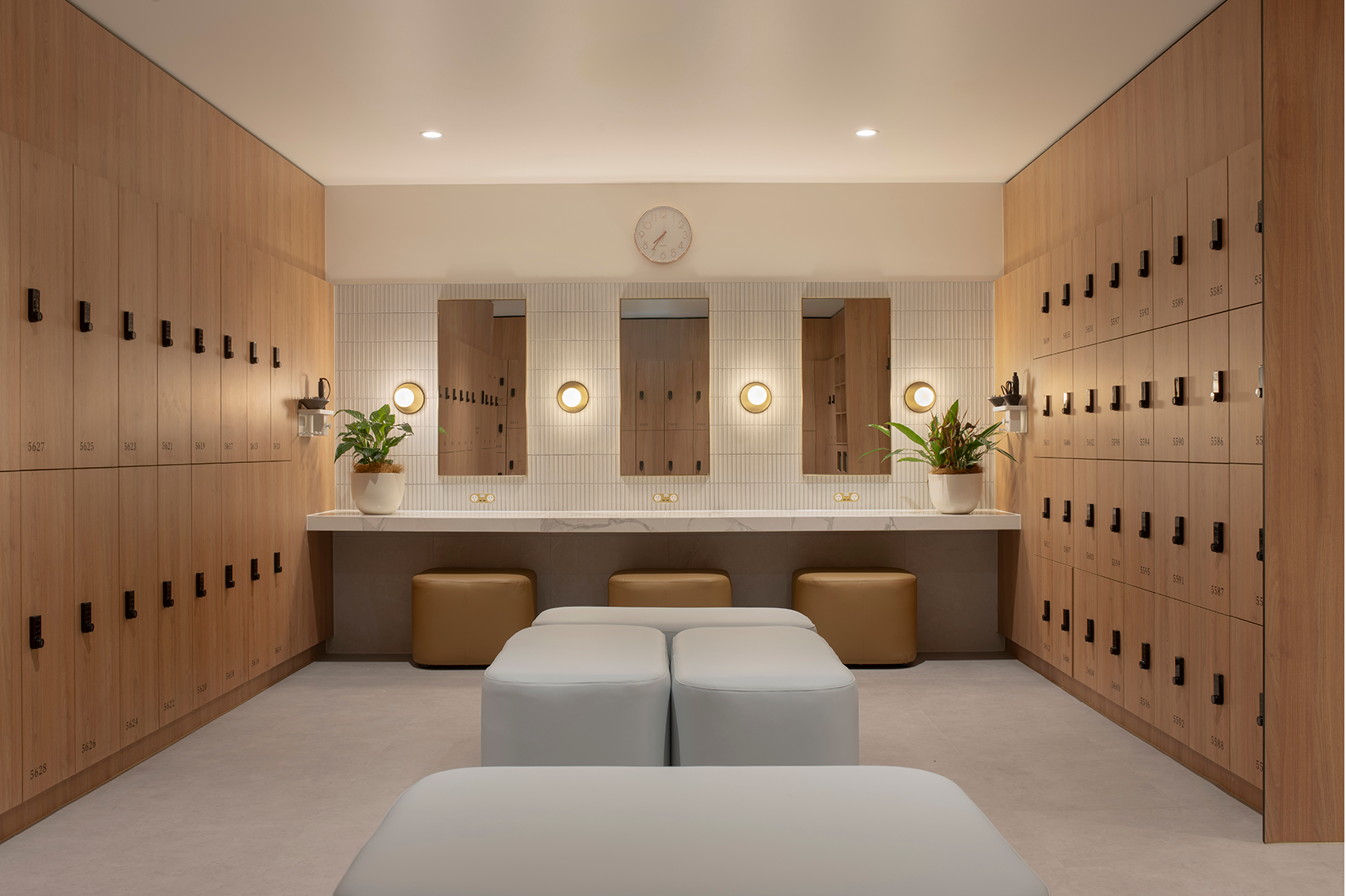 Tattersall's Club. Modern locker room with wooden lockers, mirrors, and seating; potted plants on countertops. Hospitality Interior Design Brisbane Australia
