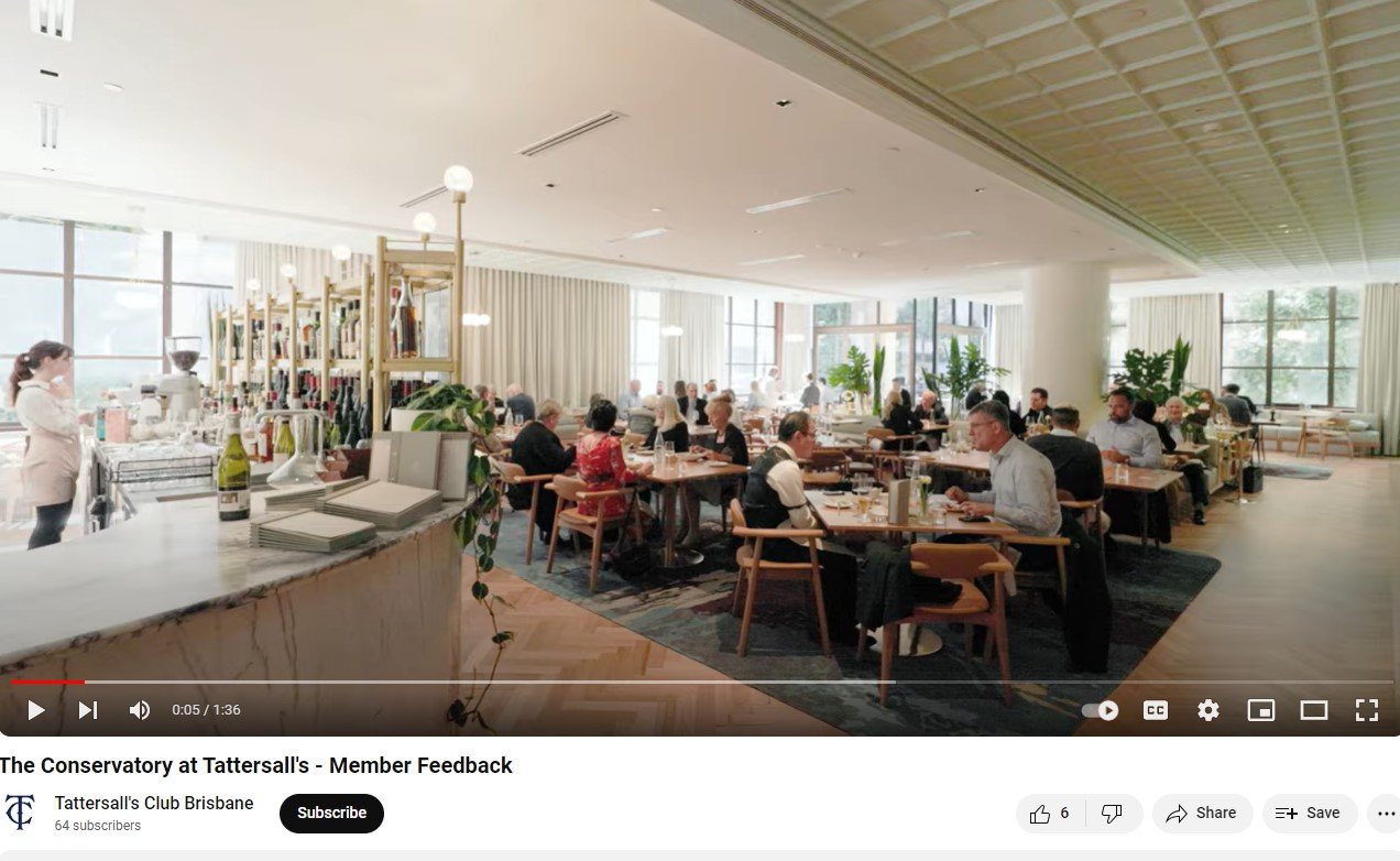 People dining in a restaurant with modern decor and large windows, featuring a bar area and potted plants. Interior Designers in Brisbane Australia