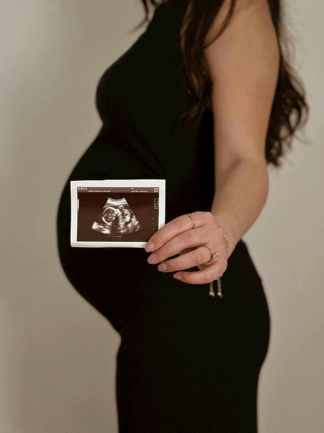 Maternity photo with scan picture and bump in black dress