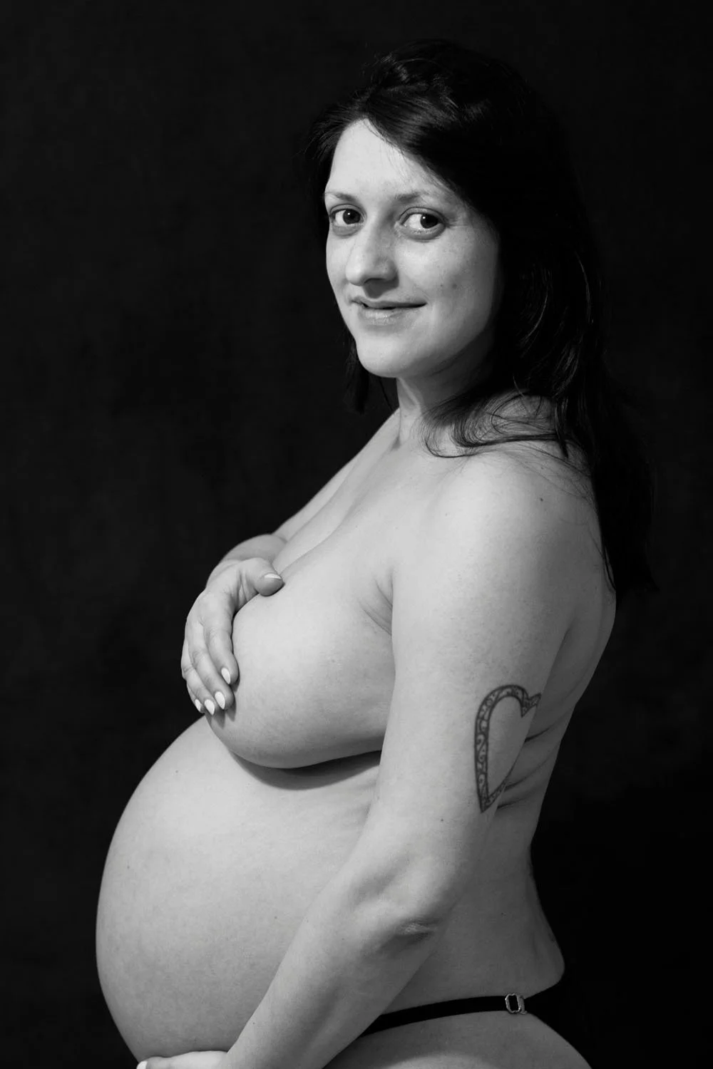 Nude pregnant woman photographed in black and white