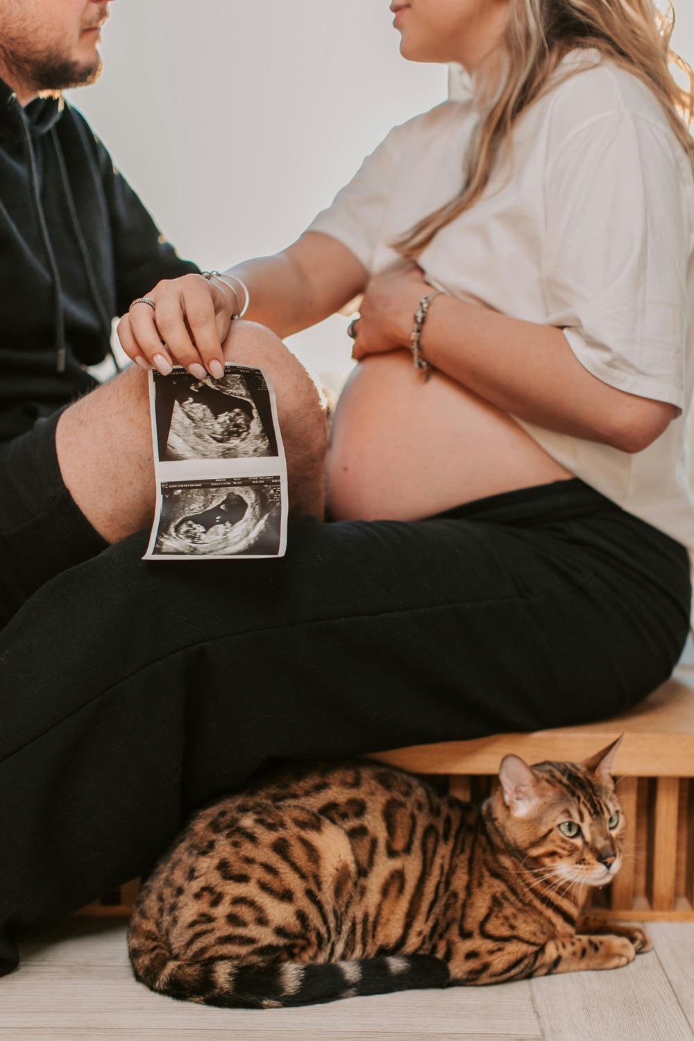 Maternity shoot with cat, partner and scan image