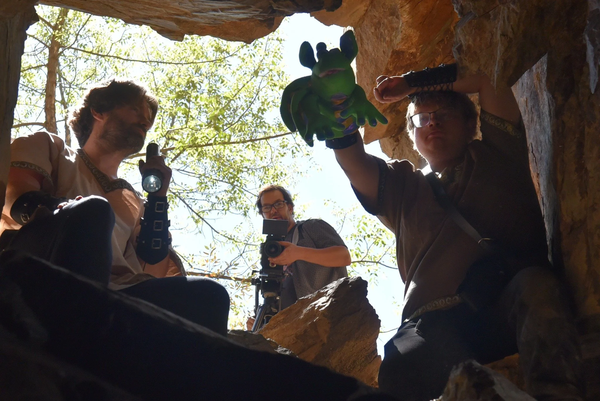 Clapperboard held by a person in a desert landscape with mountains in the background, displaying scene details and handwritten credits.