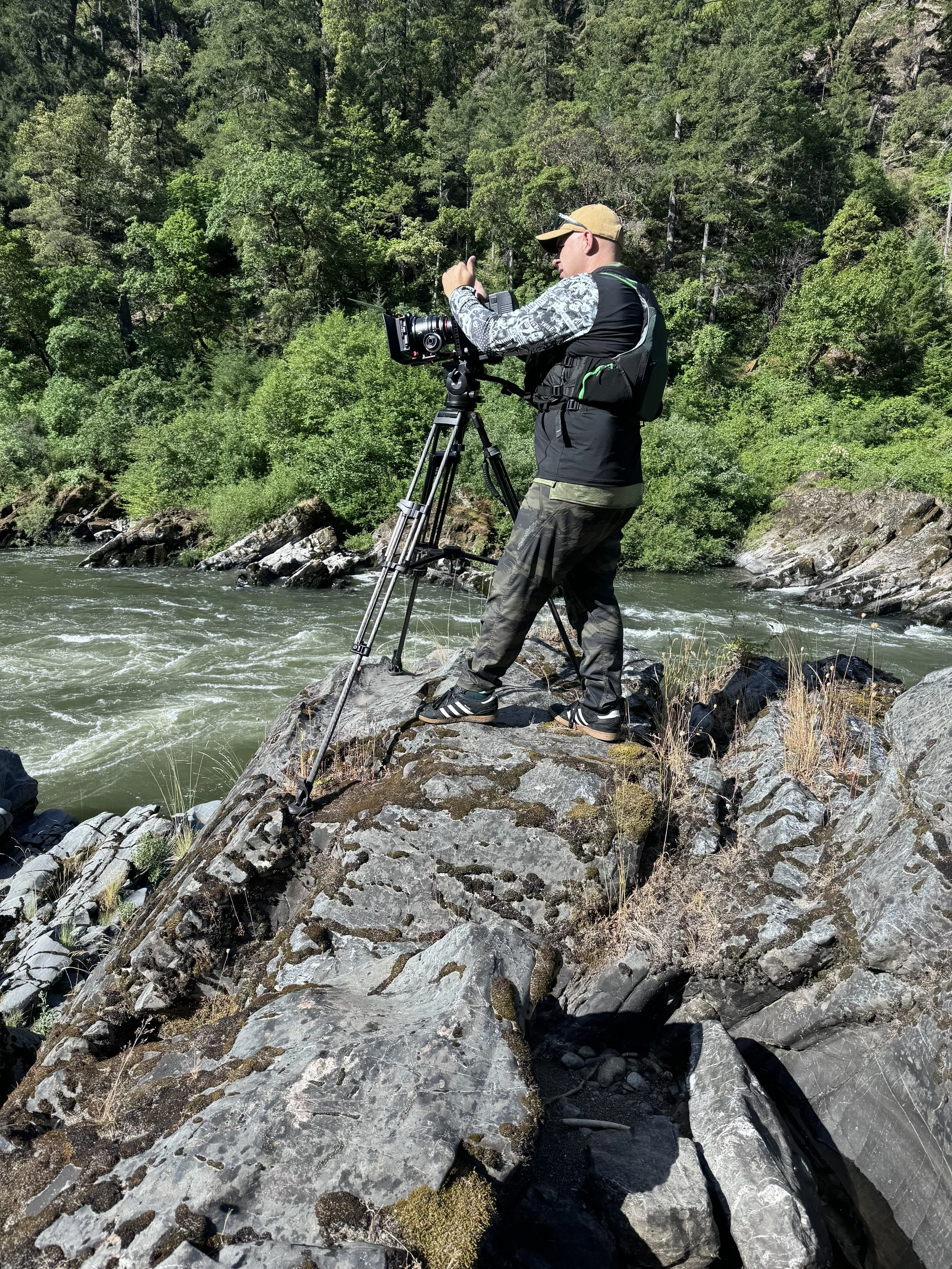 Christopher Sheets operating a camera along a lakeside taking photographs
