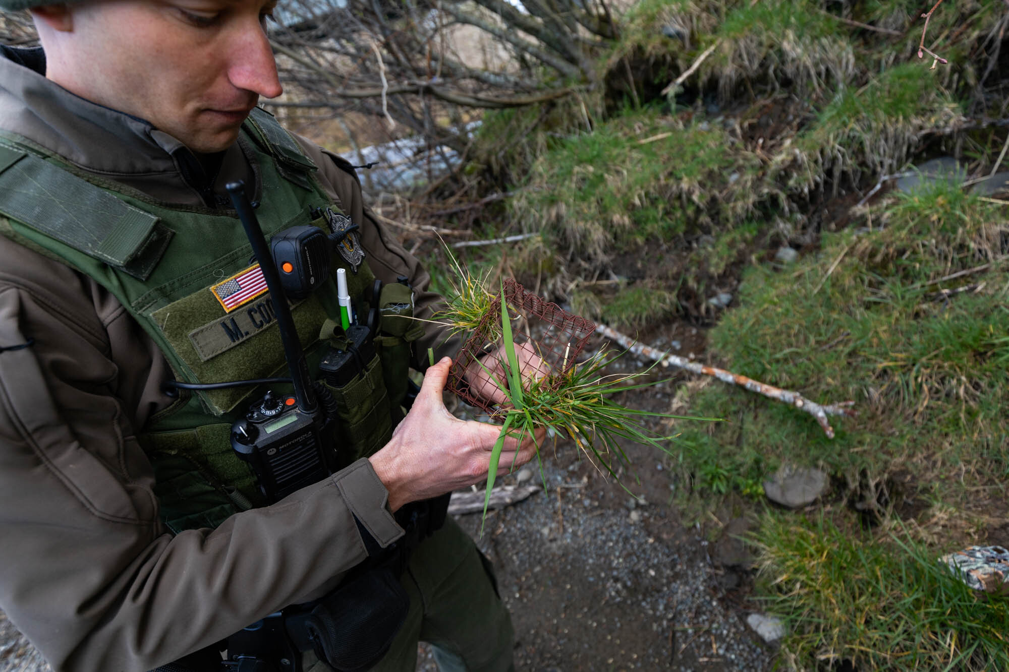 Officer Cooney demonstrates how Law Enforcement hides and installs game cameras.