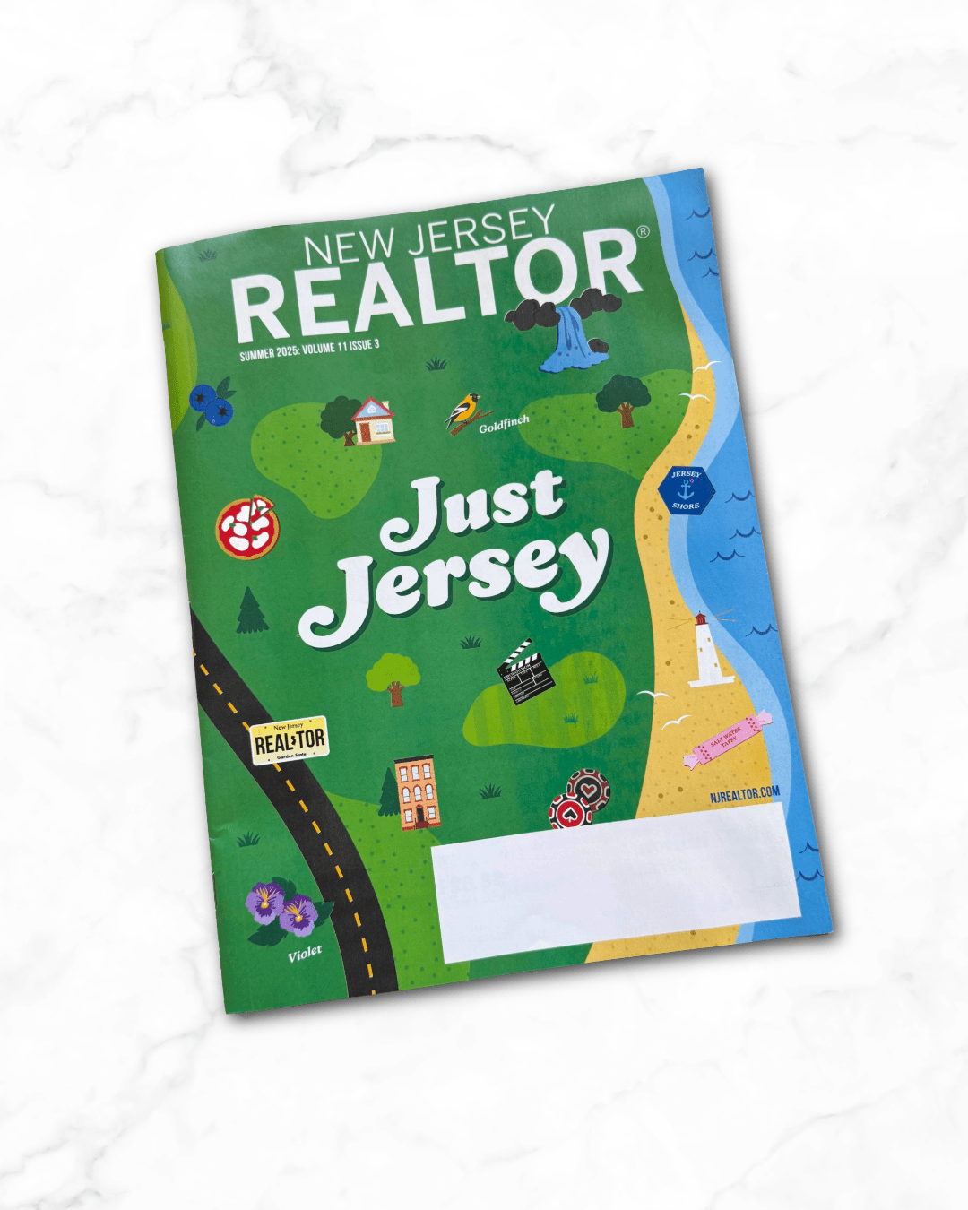 Cover of New Jersey Realtors magazine titled 'Just Jersey' with colorful illustrations of a beach, lighthouse, road, house, trees, flowers, and icons representing New Jersey such as a blueberry, a bird, and a clapperboard.