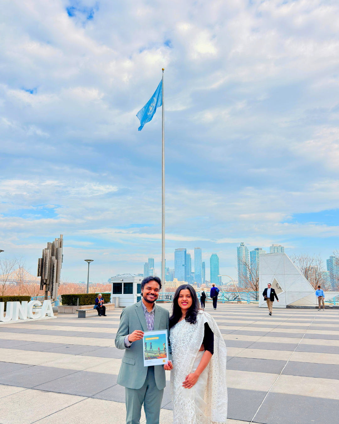 A group of people attending a policy briefing presentation in a conference room with a large screen displaying the report title 'Scaling with Cause' and '2024-25 Policy Brief'.