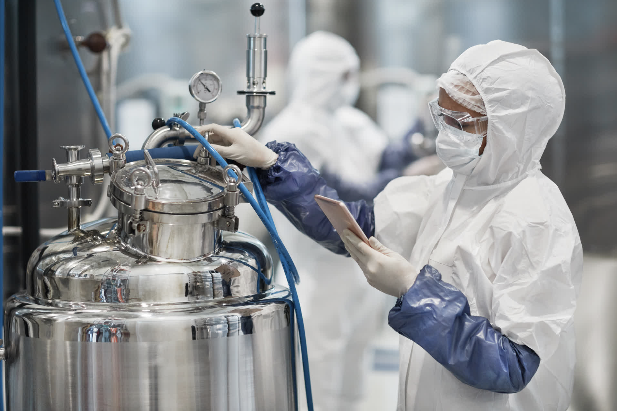 A scientist in a lab with protective gear — representing medium biotech and medical companies requiring employee coverage.