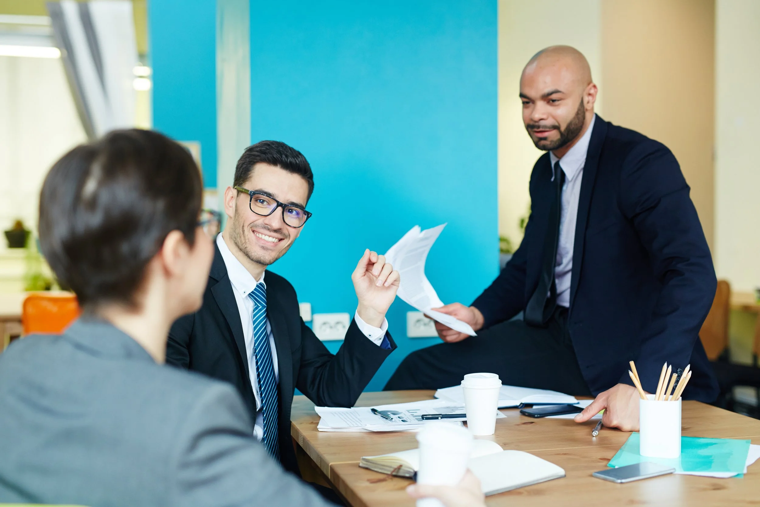 Three corporate professionals in a meeting — representing medium-sized companies exploring scalable employee benefits.