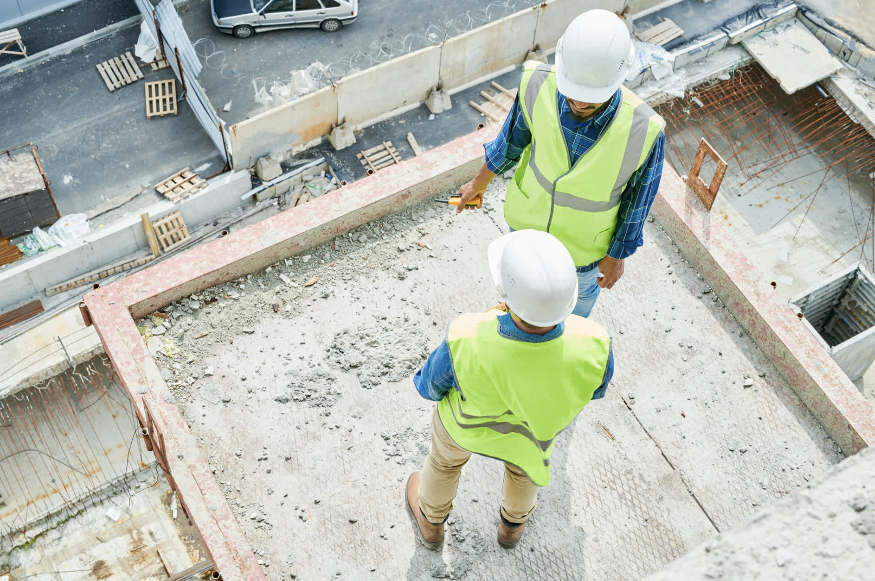 Construction workers in safety gear discussing plans — representing trades businesses needing group benefits and WSIB-aligned protection.
