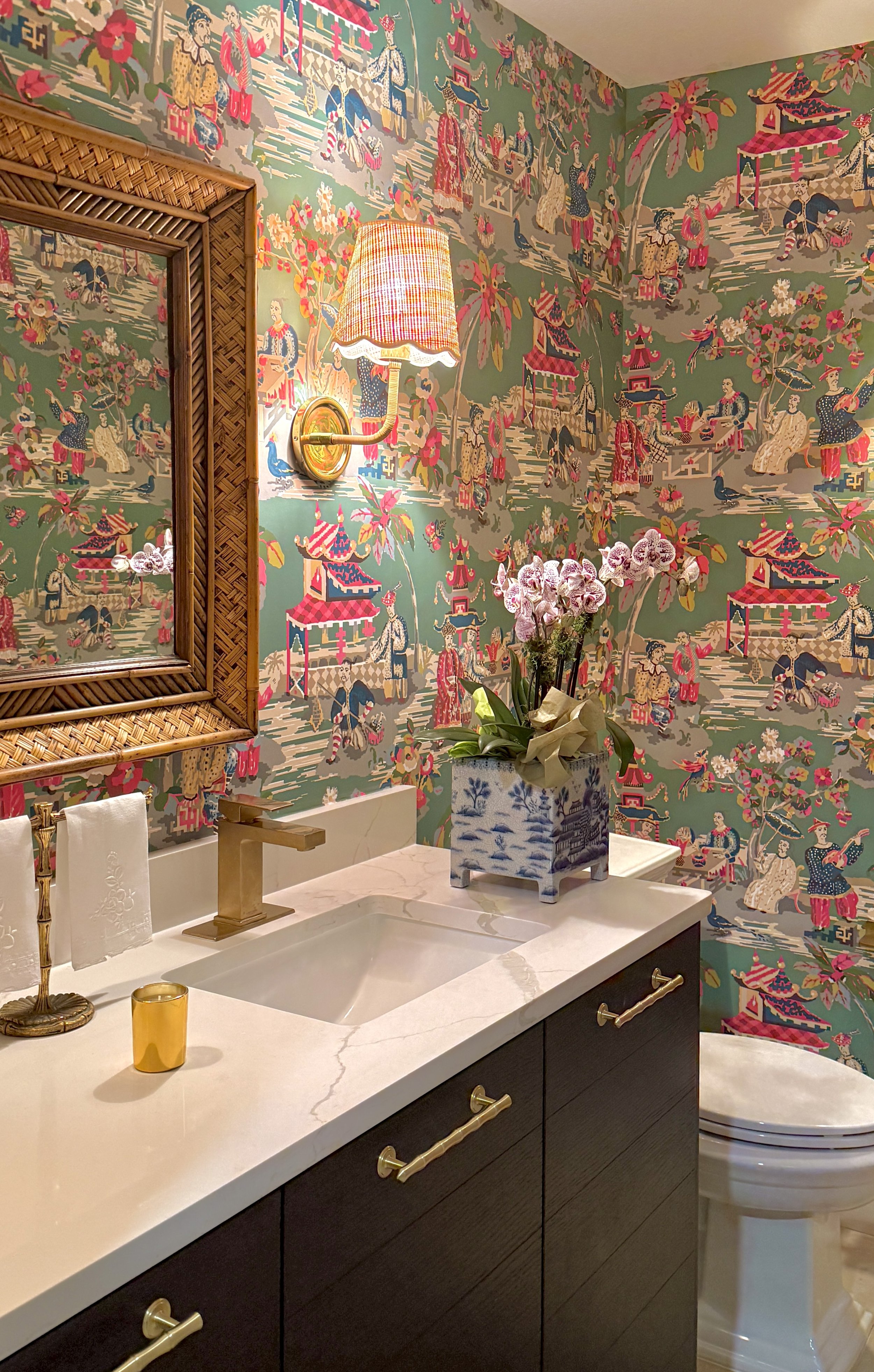Powder bath in chinoiserie wallpaper, Brunschwig and Fils Xian pattern, with rattan and brass accents.