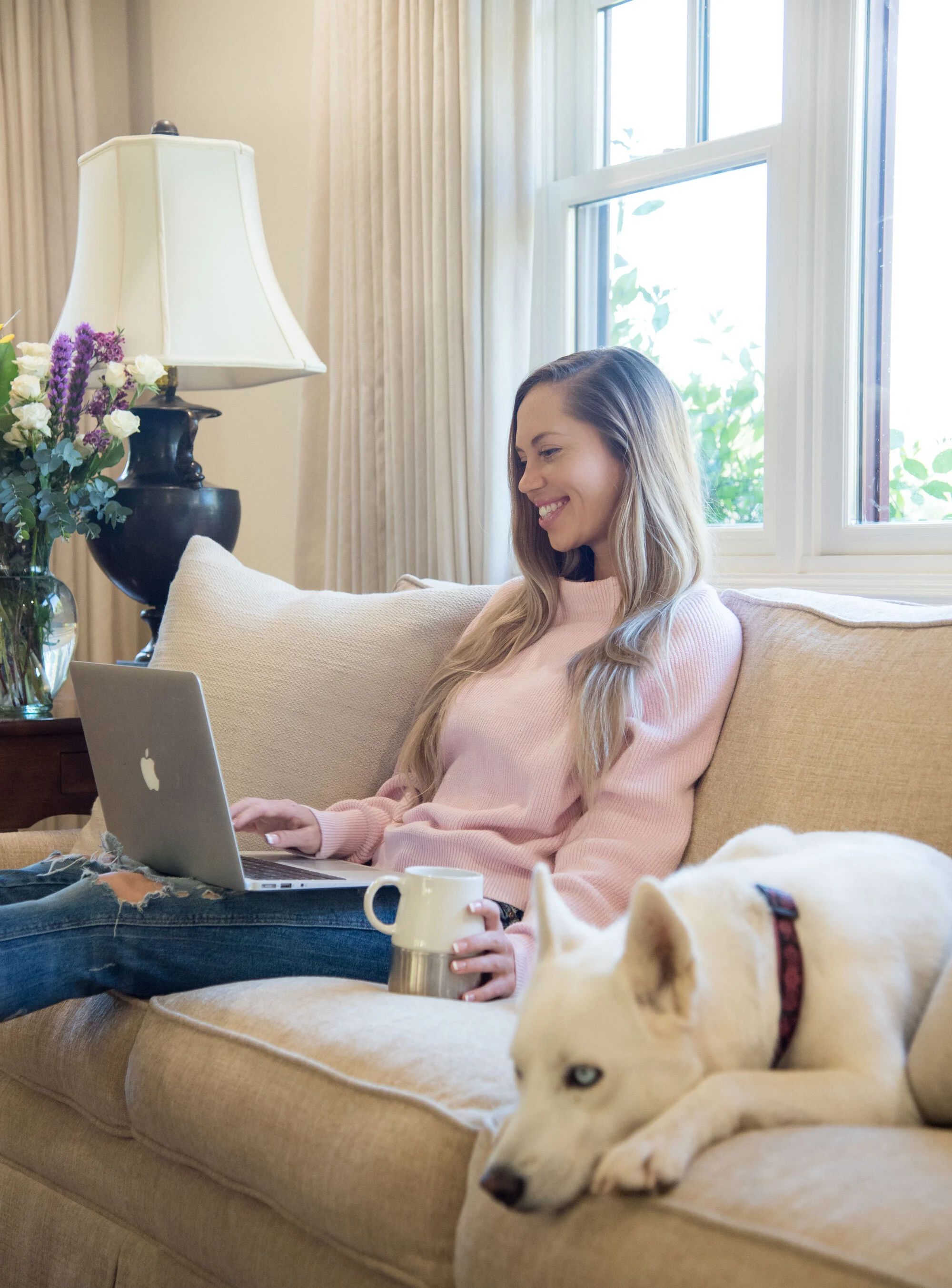 Custom Squarespace website designer Kaitlin Breuninger sitting with her laptop and dog at home
