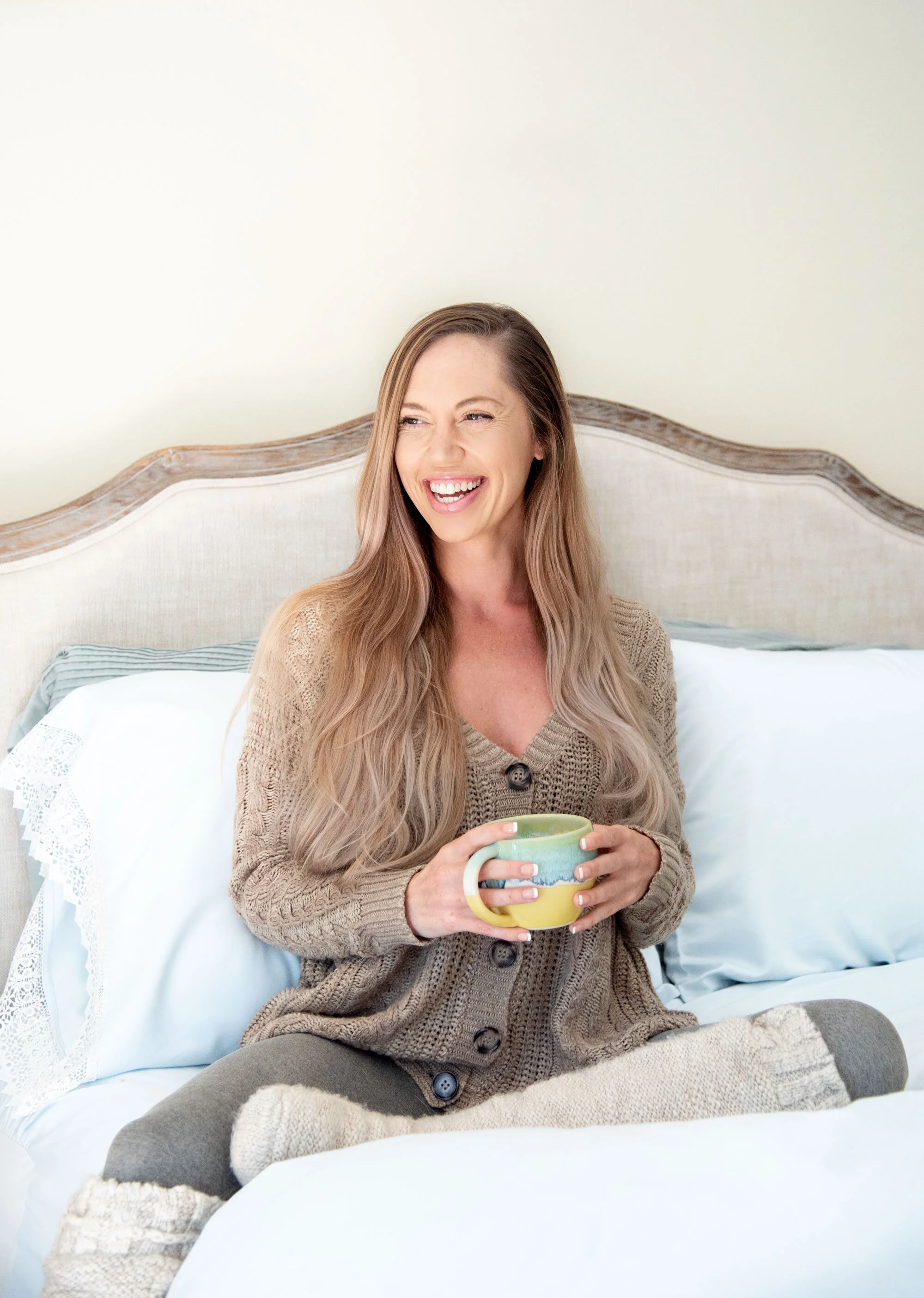 Squarespace website designer Kaitlin Breuninger smiling and holding a cup of coffee