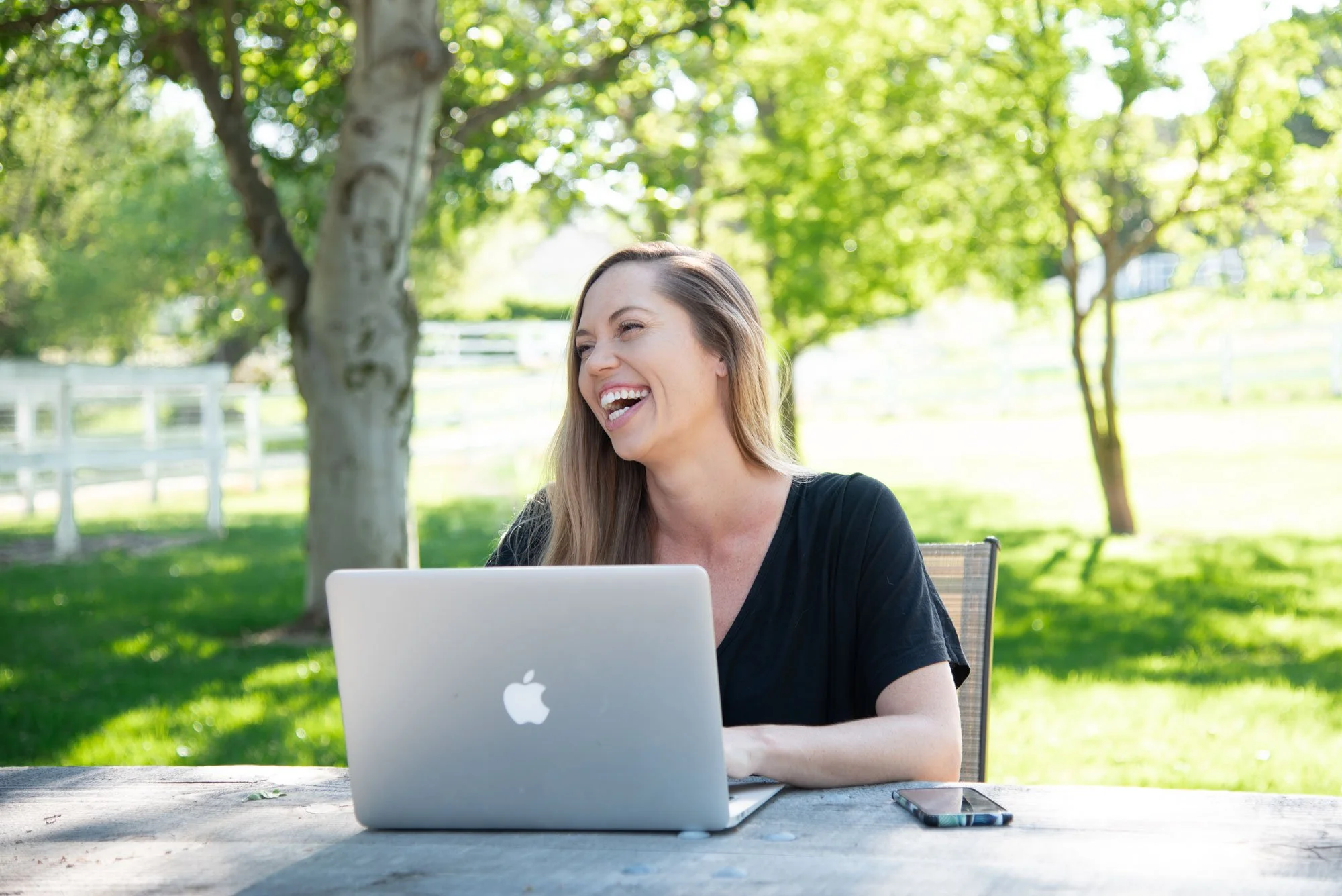 Kaitlin Breuninger working on a custom Squarespace website outdoors on her laptop