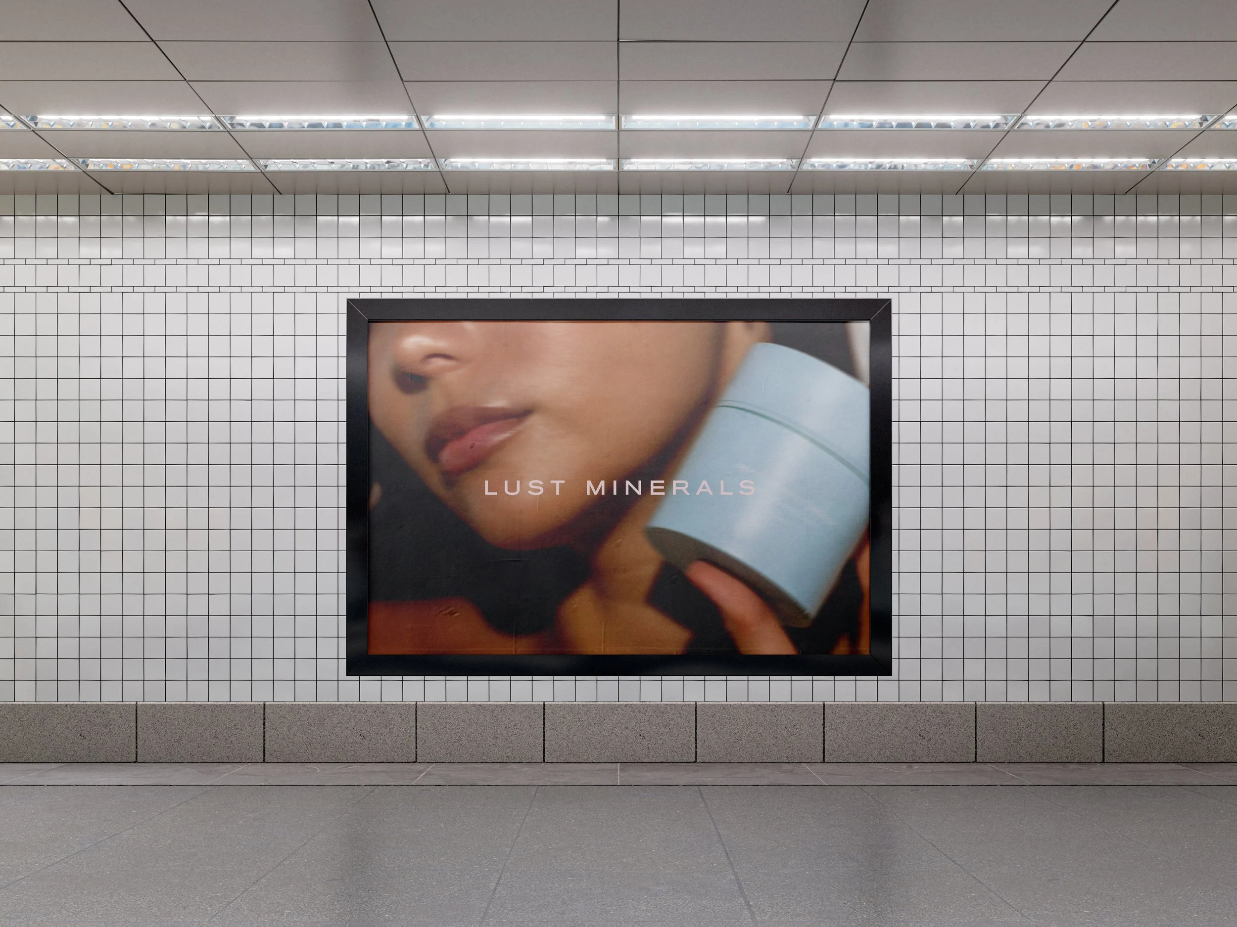 Advertisement poster featuring a close-up of a woman holding a container, with the text "LUST MINERALS" on it, displayed in an underground subway station.