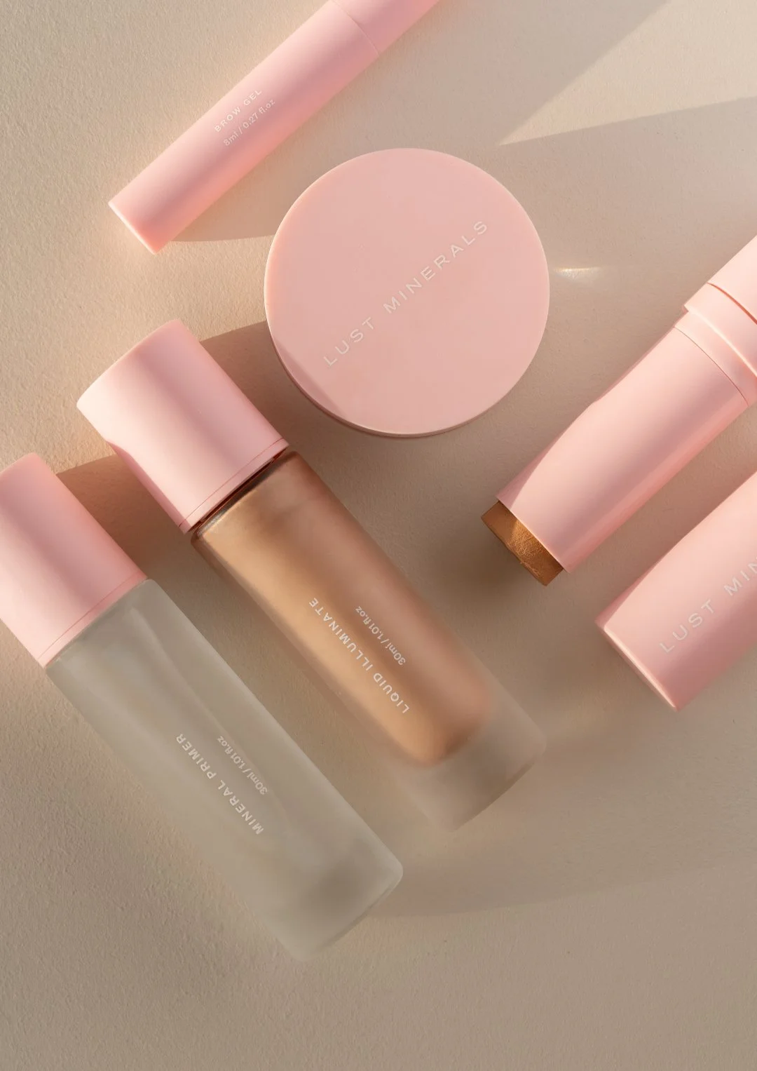 Arrangement of skincare products including pink-labeled containers and bottles on a light surface.