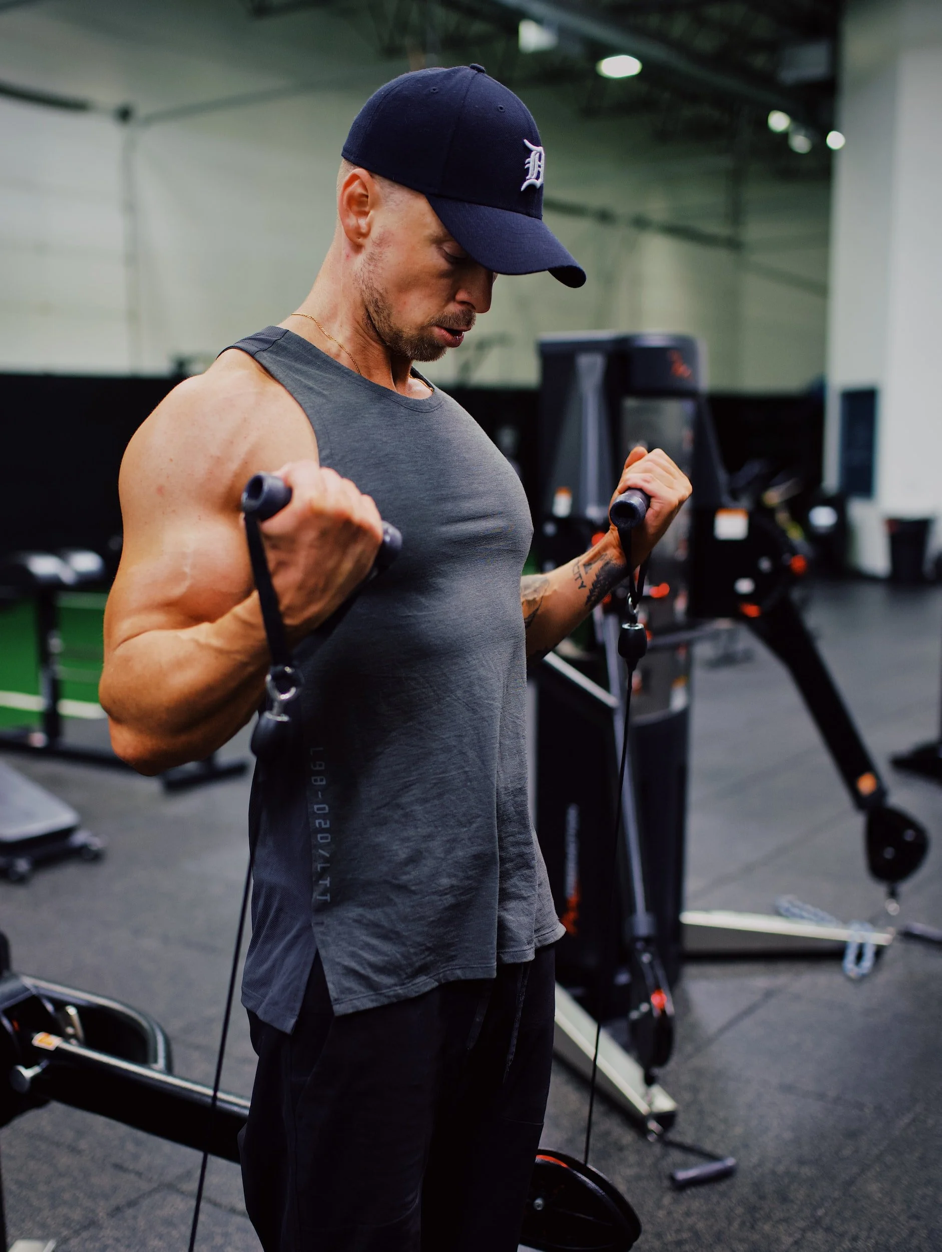 Fit guy doing biceps curl cable in a gym