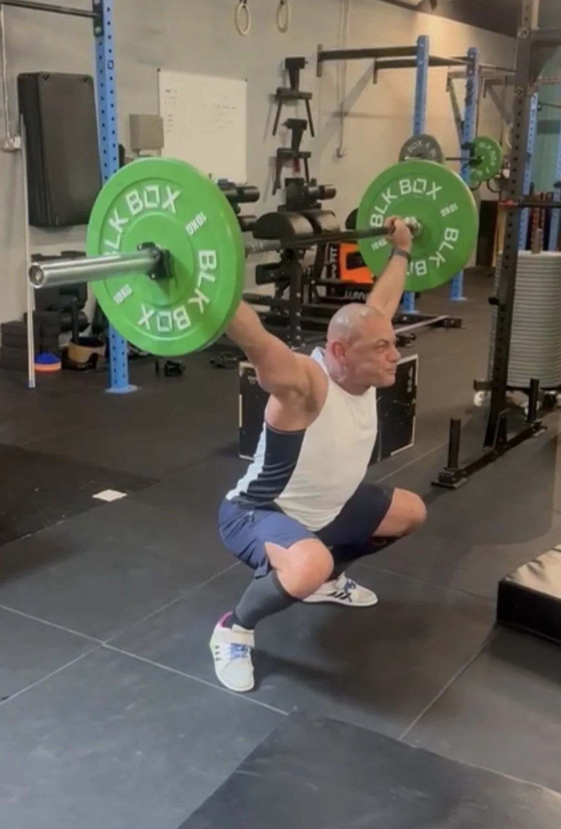 Personal trainer Omar Ryan performing an Olympic weightlifting overhead squat at a personal training studio in Islington, London.