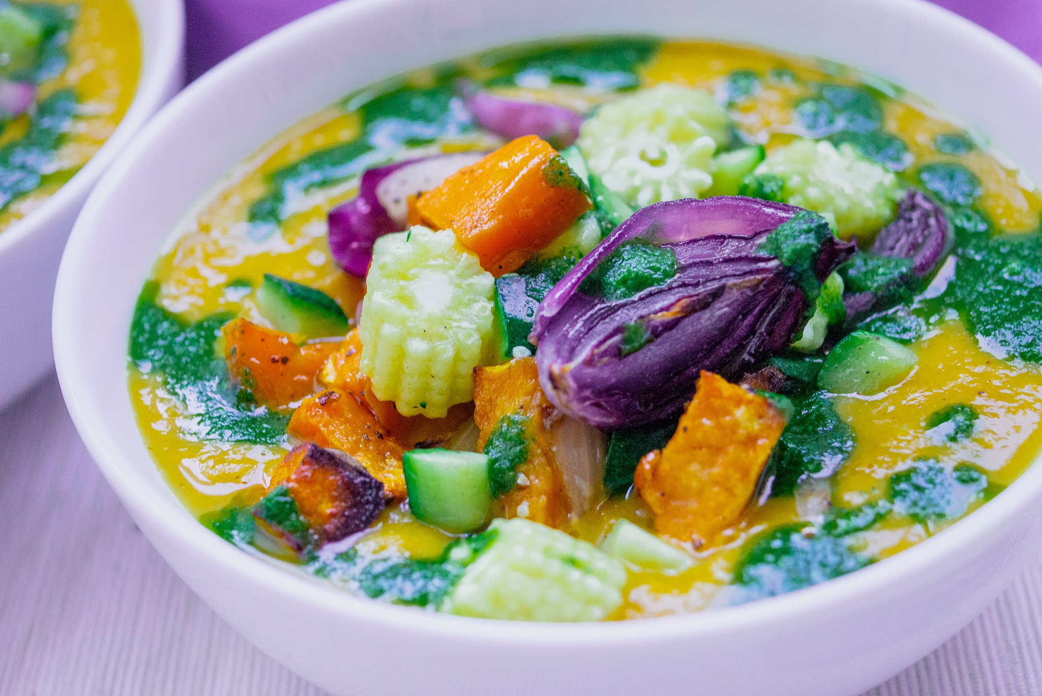 lentil and butternut squash soup in a white bowl with roasted vegetable garnish