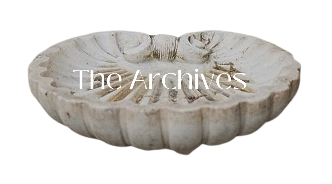 White stone shell-shaped bowl with 'The Archives' text overlay