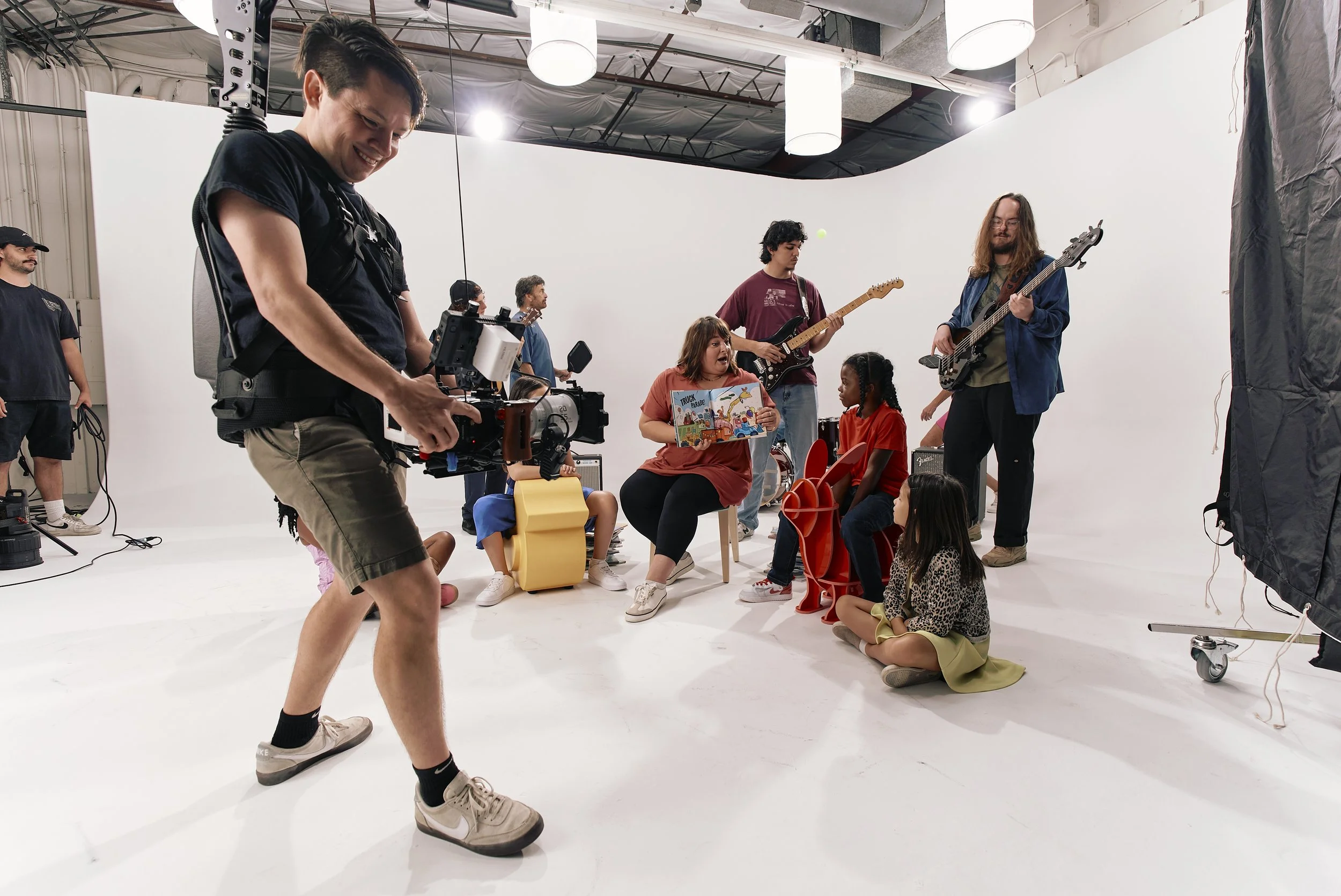 Camera man captures a group read-along in a studio.