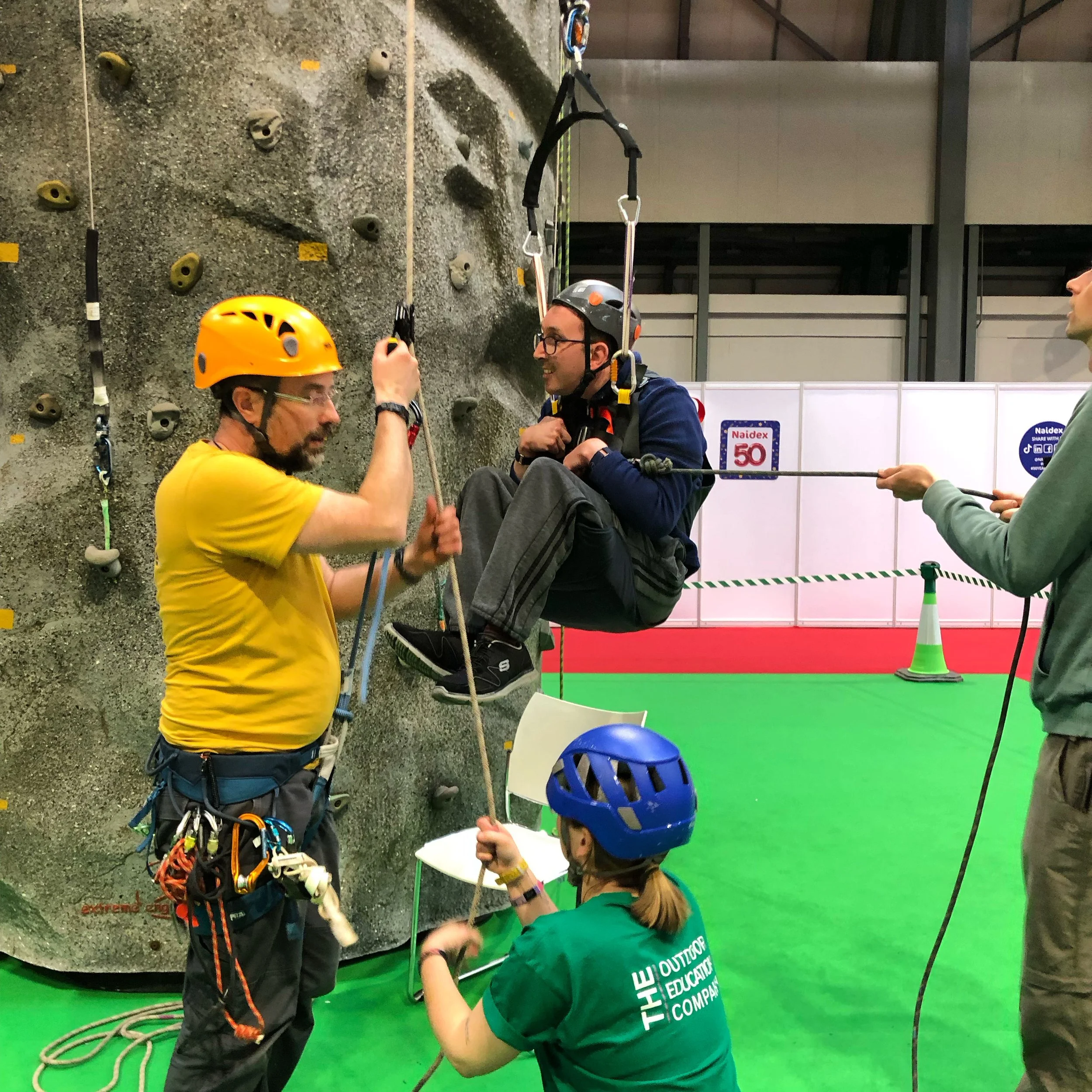 instructors helping a wheelchair user climb