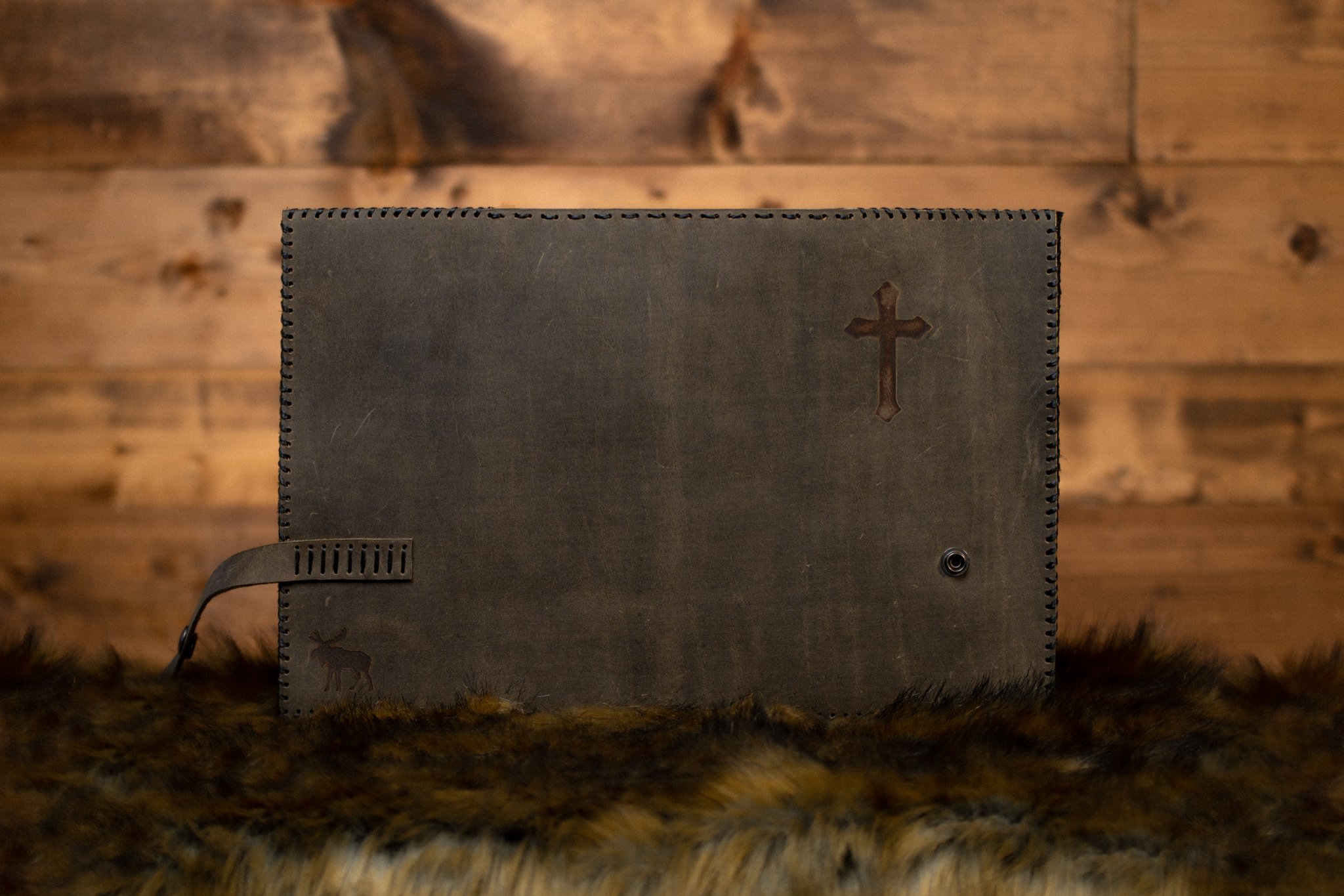 open distressed leather cover with cross on rustic background