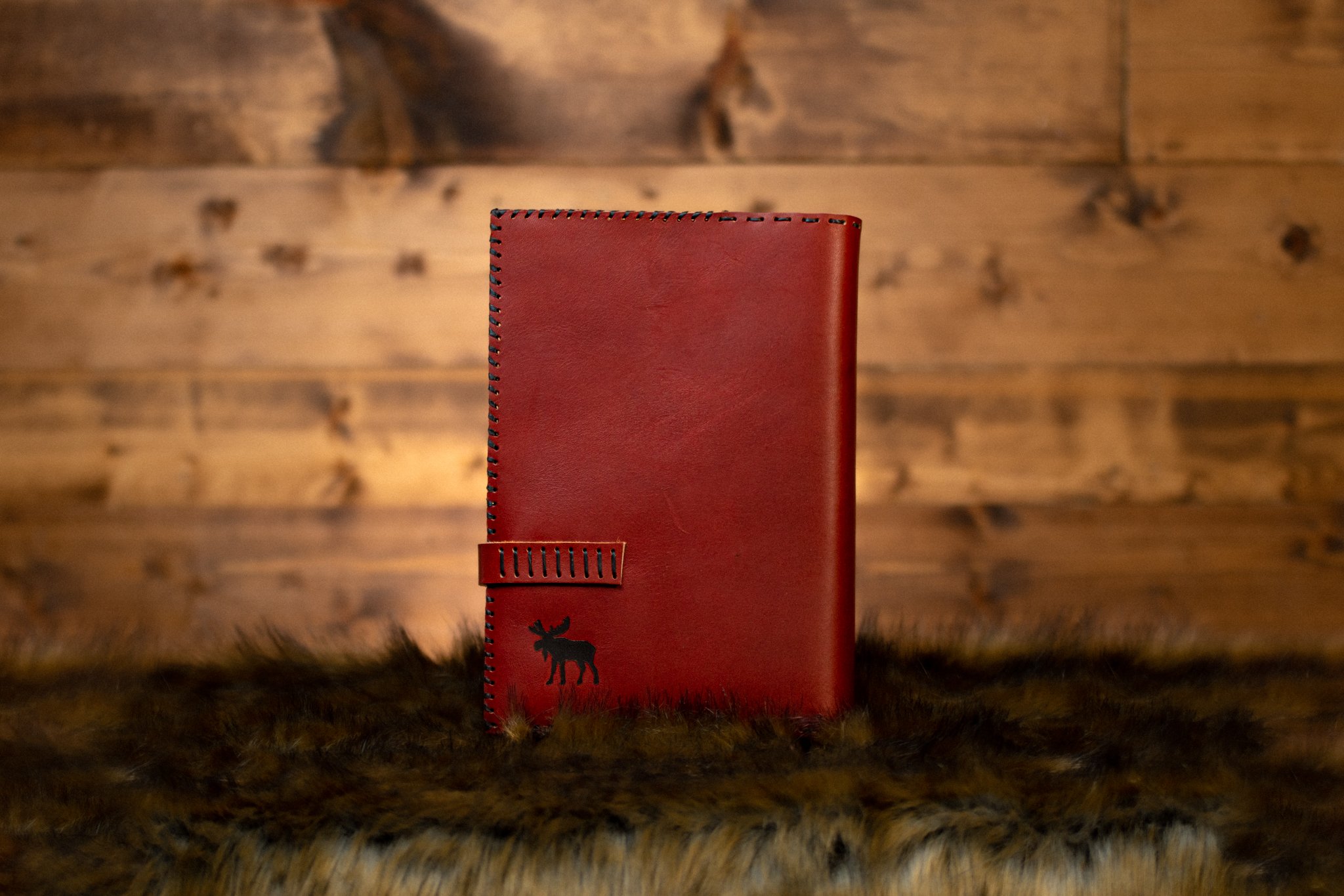 Deep red bible cover with moose on wood backdrop (Copy) (Copy)