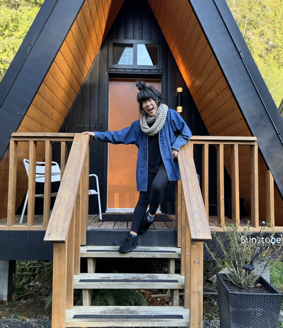 a girl smiling and leaning against an a-frame railing with rainbow socks