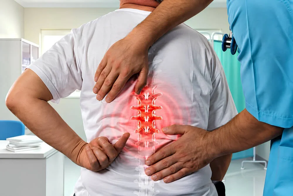 Doctor's hands on a patient's back, with the spine highlighted to show a compression fracture