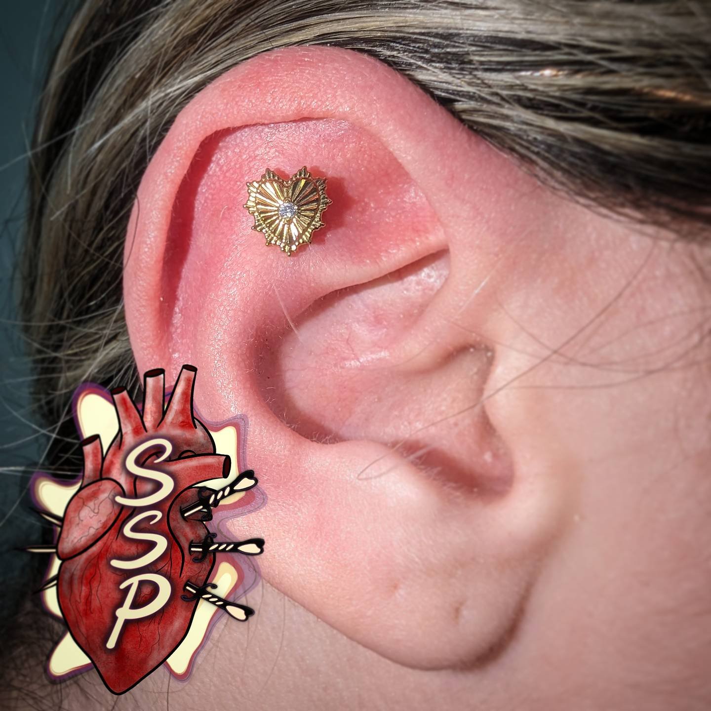 Flat piercing with an amazing titanium heart that was anadized gold. Probably my favorite piece we've gotten in.

If you're interested in coming in for a piercing. There is no appointment needed, you can just come into the shop while we are open. Any