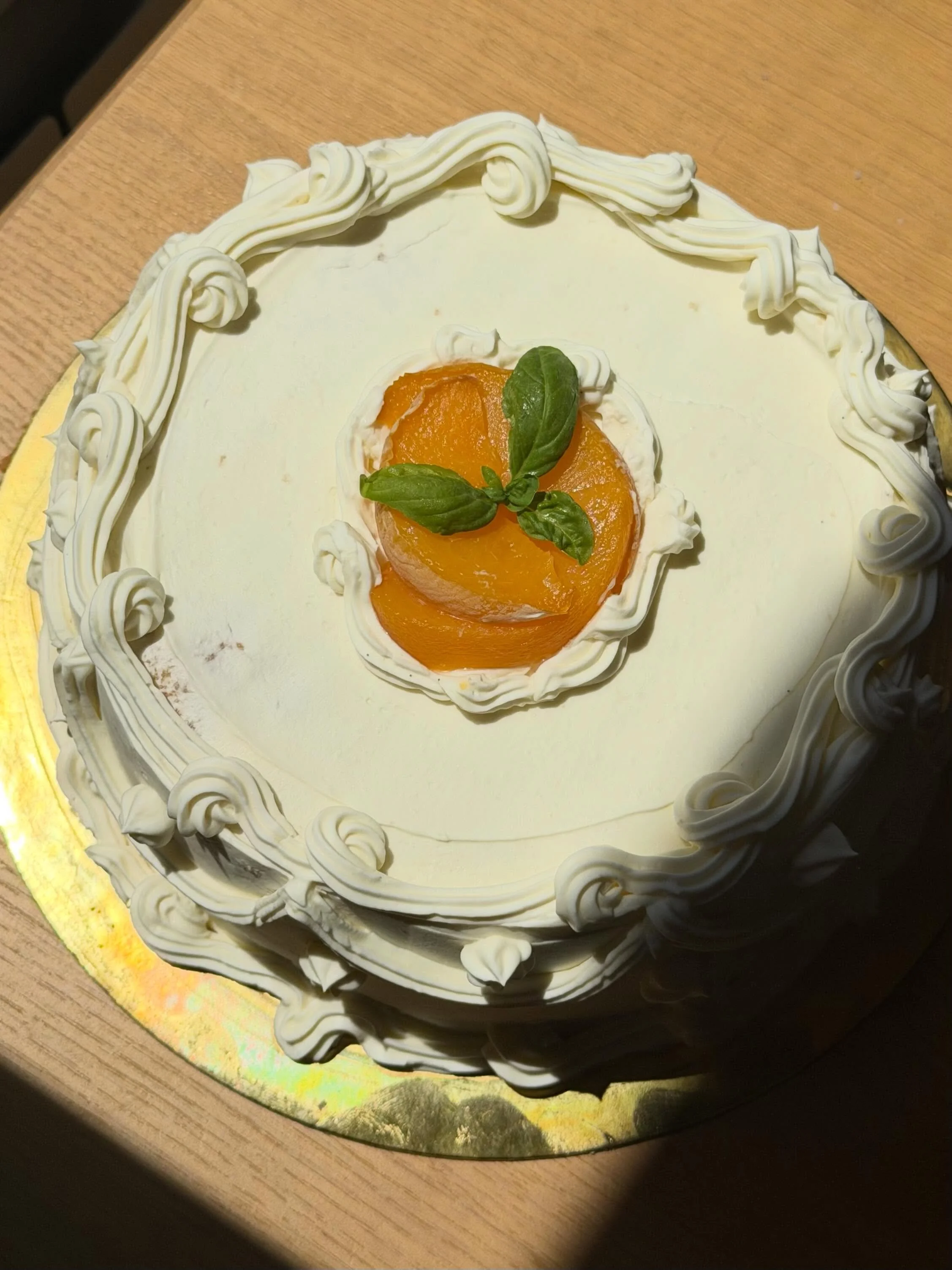 Making the most of the amazing summer peaches in Spain at the moment✨ almond sponge cake filled with poached peaches and whipped basil ganache lightly soaked with the peach poaching liquor and covered in a salty olive oil and vanilla Italian meringue