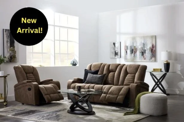 Bright living room with white walls. Big window, and a brown reclining living room set.